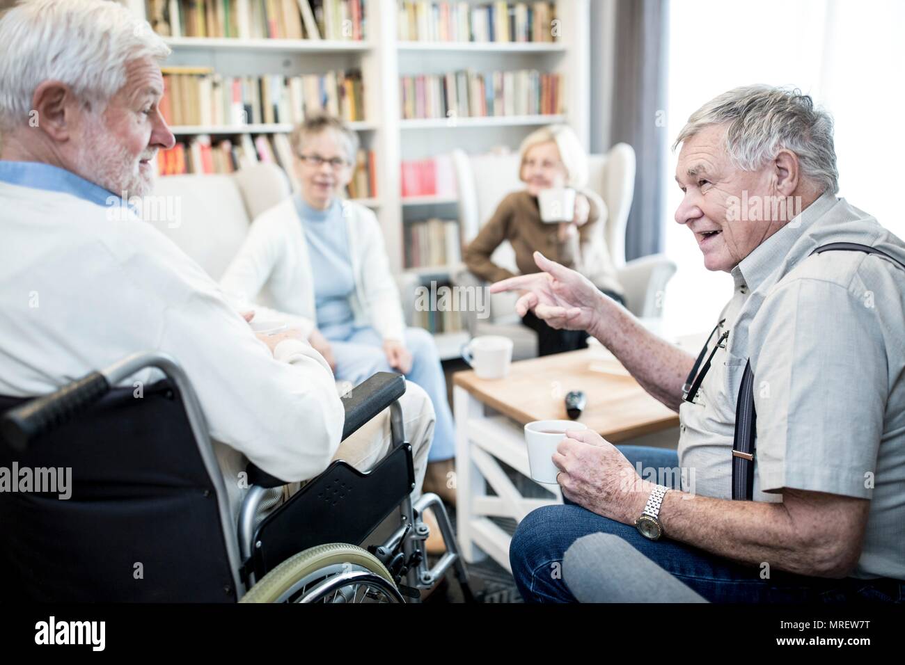 Älterer Mann im Rollstuhl sprechen in der Pflege zu Hause Fiend. Stockfoto