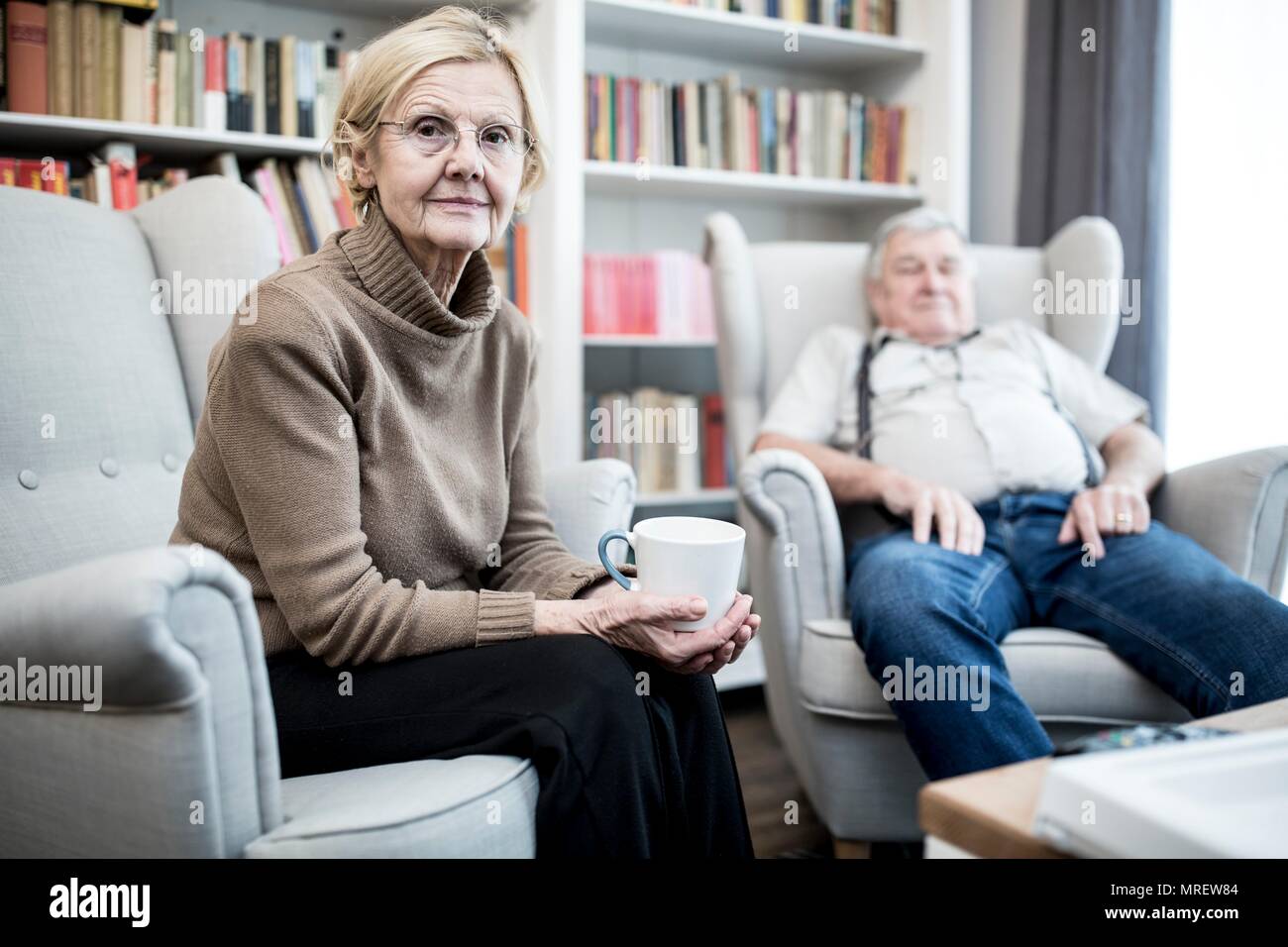 Senior Paar sitzen auf Sesseln, Portrait. Stockfoto