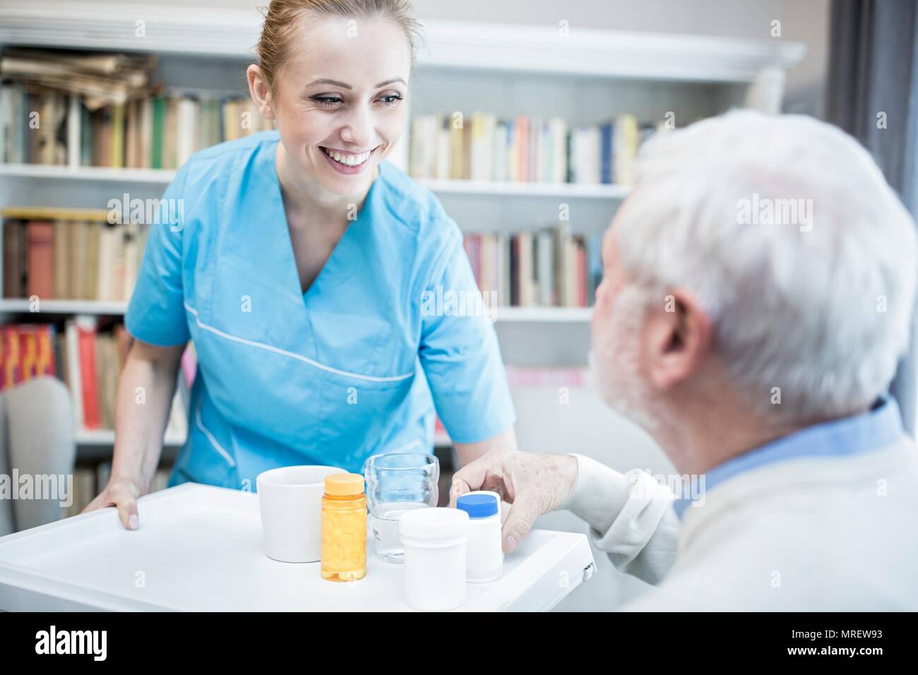 Care worker und älterer Mann mit Medizin Flaschen. Stockfoto