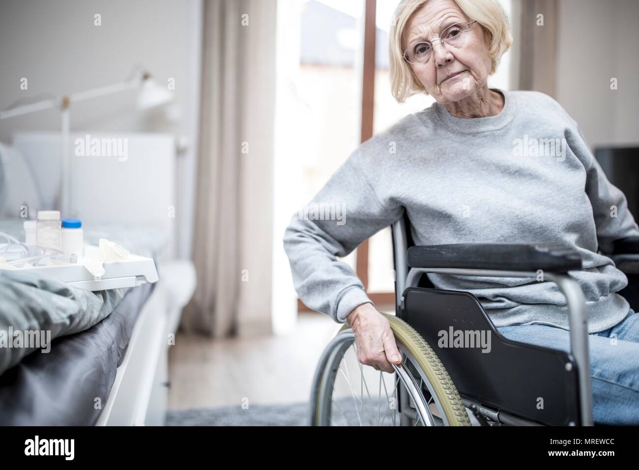 Ältere Frau im Rollstuhl in der Pflege zu Hause. Stockfoto