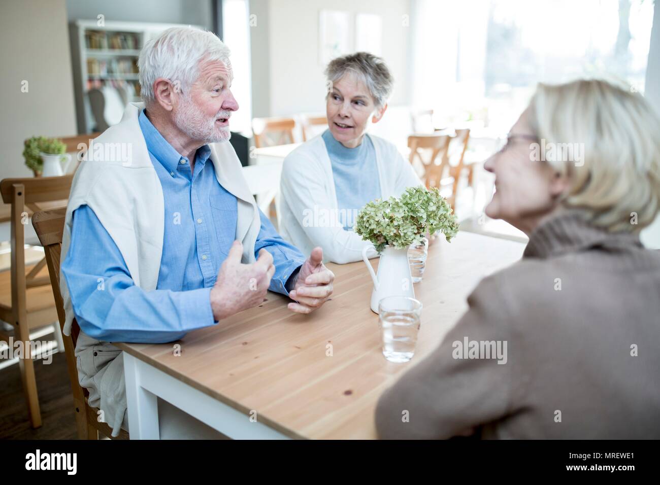 Älterer Mann zu zwei weibliche Freunde in der Pflege zu Hause sprechen. Stockfoto