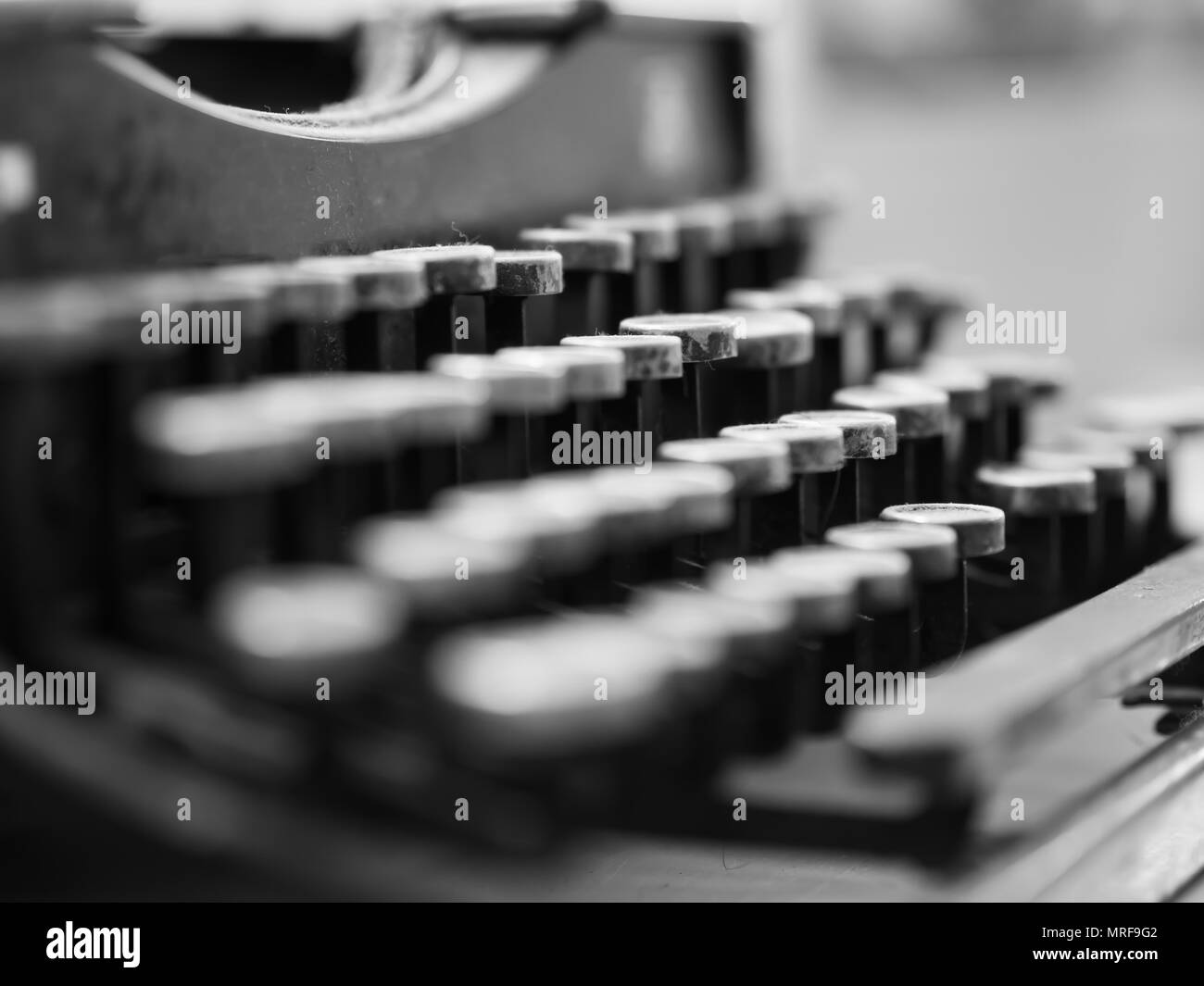 Staubige antike Schreibmaschine mit Fokus auf die Tasten in Schwarz und Weiß Stockfoto