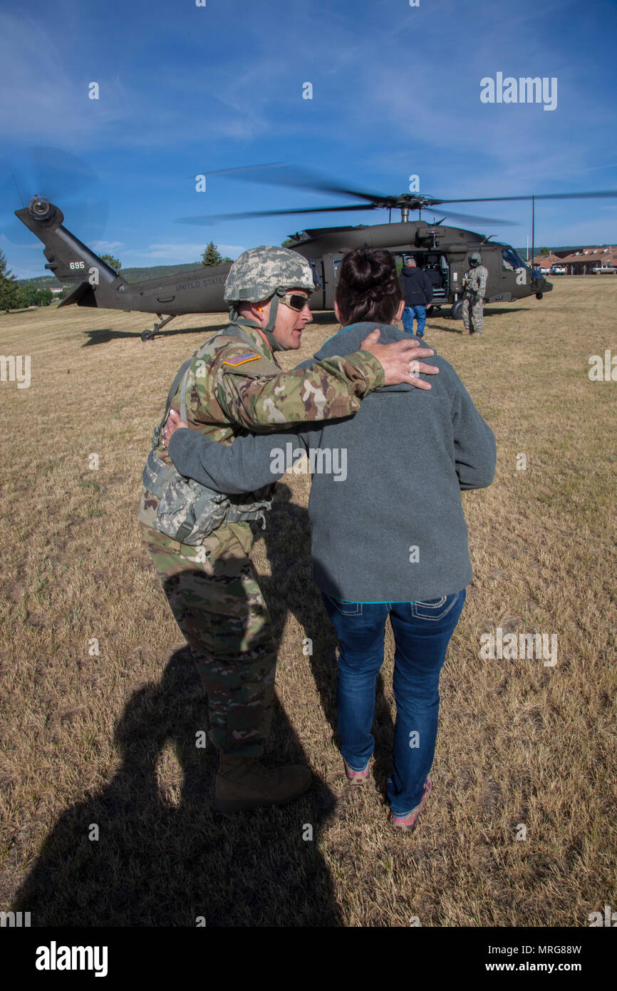 Us-Armee Master Sgt. Mike Dotson, Crew Chief mit Joint Force Head Quarters, South Dakota Army National Guard spricht mit Kim Vanneman Mitglied der South Dakota der militärischen Angelegenheiten, bevor ein HH-60 M MEDEVAC Black Hawk Verpflegung während der Goldenen Coyote Übung in Rapid City, S.D., 15. Juni 2017. Die goldenen Coyote Übung ist eine dreiphasige, Szenario-driven Übung in den Black Hills von South Dakota und Wyoming, mit dem Kommandanten auf der Mission wesentliche Anforderungen der Aufgabe, Krieger Aufgaben und Übungen zu konzentrieren. (U.S. Armee Foto von SPC. Kevin Kim) Stockfoto