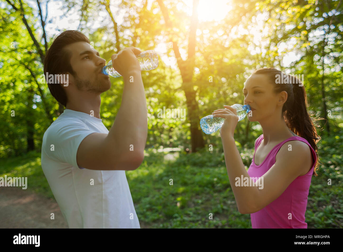 Junges Paar trainieren in Park. Sie sind Trinkwasser. Stockfoto