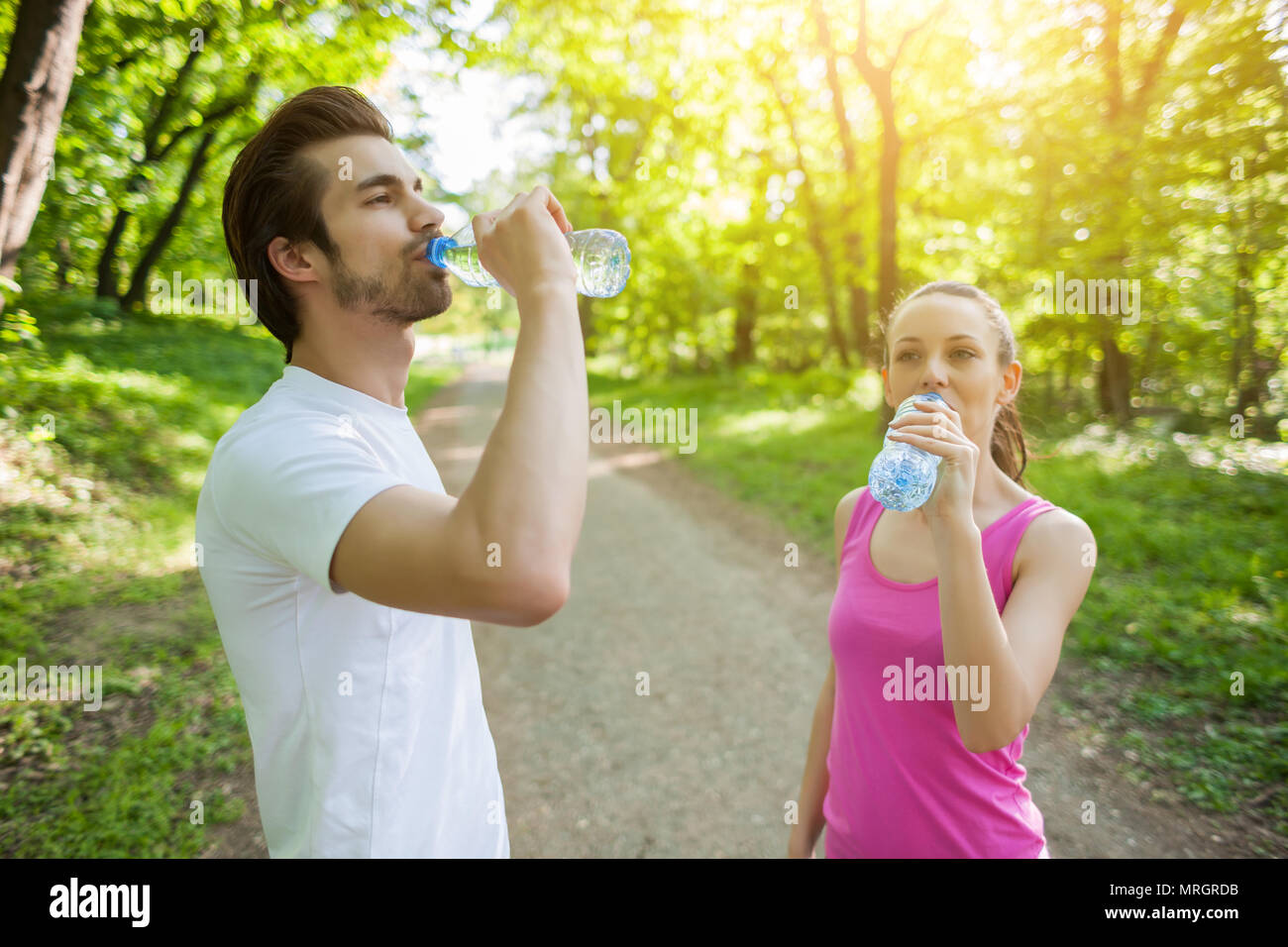 Junges Paar trainieren in Park. Sie sind Trinkwasser. Stockfoto