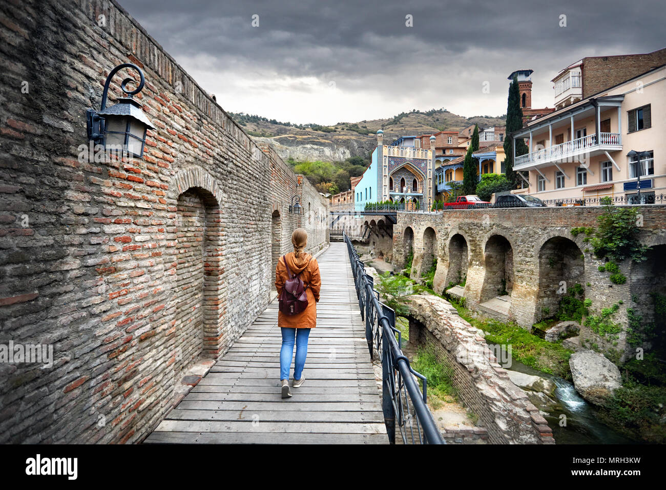 Touristische Frau in braunen Sakko Spaziergang durch die alten Straßen von öffentlichen Schwefelsäure Badewanne Bezirk im Zentrum von Tiflis, Georgien Stockfoto