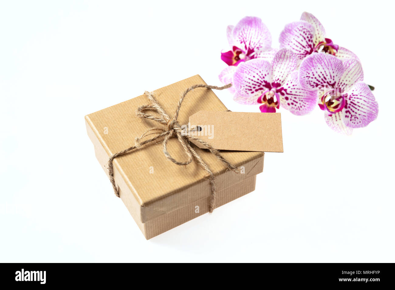 Orchidee rosa Blüten und einem Geschenkkarton mit einer leeren tag auf einem weißen Hintergrund, Platz für Text Stockfoto