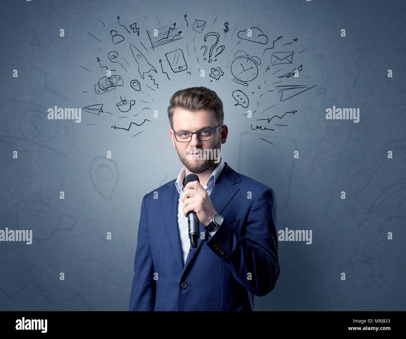 Geschäftsmann sprechen in das Mikrofon mit gemischten Doodles über seinem Kopf Stockfoto