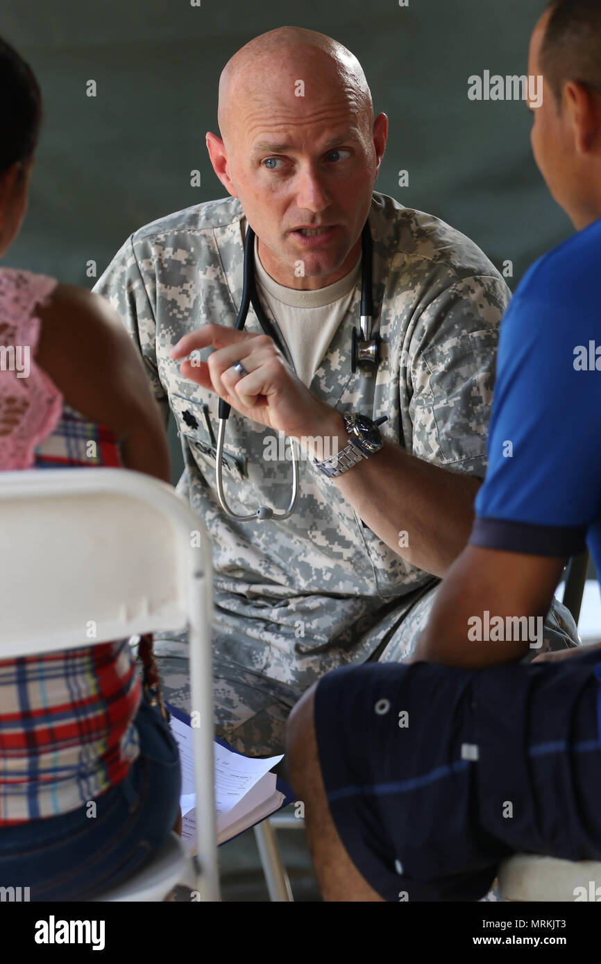 Oberstleutnant Derrick Kooker, ein Denkmal, Oberst Eingeborene, der als Assistent des Arztes für die Wyoming National Guard, Medizinische Abteilung dient, spricht mit einem Patienten an Macal River Park in San Ignacio, Belize, 15. Mai 2017, während einer medizinischen Ereignis werden durch gehostete über dem Horizont 2017. Kooker und ein medizinisches Team, bestehend aus lokalen und ausländischen medizinischen Fachleuten verabreicht freie ärztliche Behandlung von über 5.300 Patienten über einen Zeitraum von zehn Tagen. (US Army Foto von Sgt. 1. Klasse Whitney Houston) Stockfoto