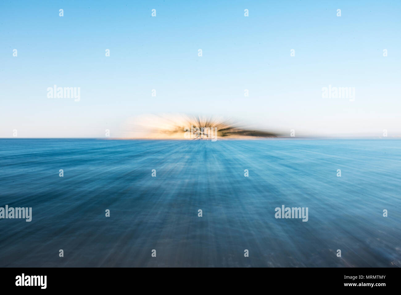 Abstrakte Beschleunigung wie Zoom über das Meer mit einer Insel am Horizont. Stockfoto