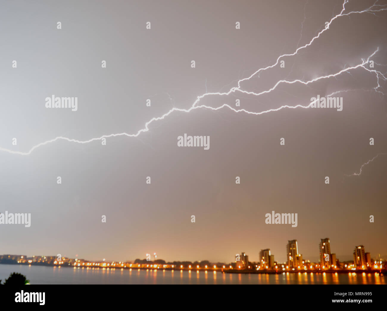 London, UK, 27. Mai 2018 in der Nacht Gewitter über die Themse in London auf einer Bank Holiday Wochenende gesehen mit einem Blitz auf den Boden in der Nähe eines Mehrfamilienhauses. Credit: Christy/Alamy Leben Nachrichten. Stockfoto