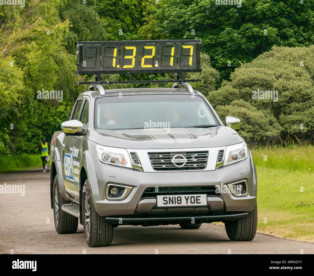 Edinburgh Marathon Festival, 26. Mai 2018. Gosford Estate, East Lothian, Schottland, Großbritannien. Elite kenianische Marathonläufer, Benjamin Kiptoo Kolum, mit den Füßen in der Luft führenden bei der Meile 18, war der Sieger des Rennens mit einem neuen Datensatz für diese Veranstaltung von 2 Stunden, 33 Minuten und 13 Sekunden. Die Leitung Auto mit verstrichene Zeit auf digitales Dach Anzeige Stockfoto