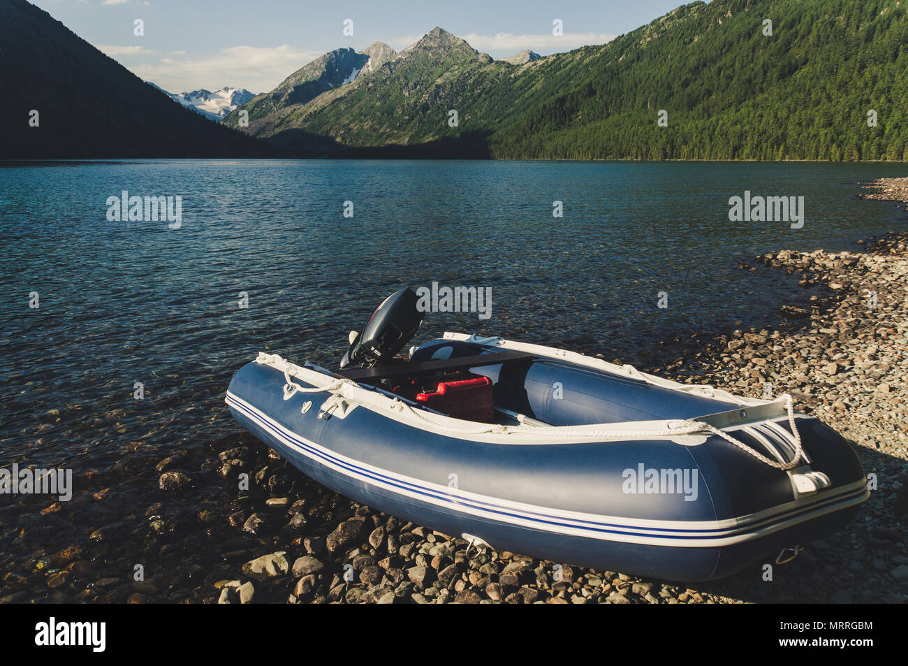 Schlauchboot mit Motor auf einem schönen malerischen See. Fischerboot auf  dem Hintergrund der schönen Berge Stockfotografie - Alamy