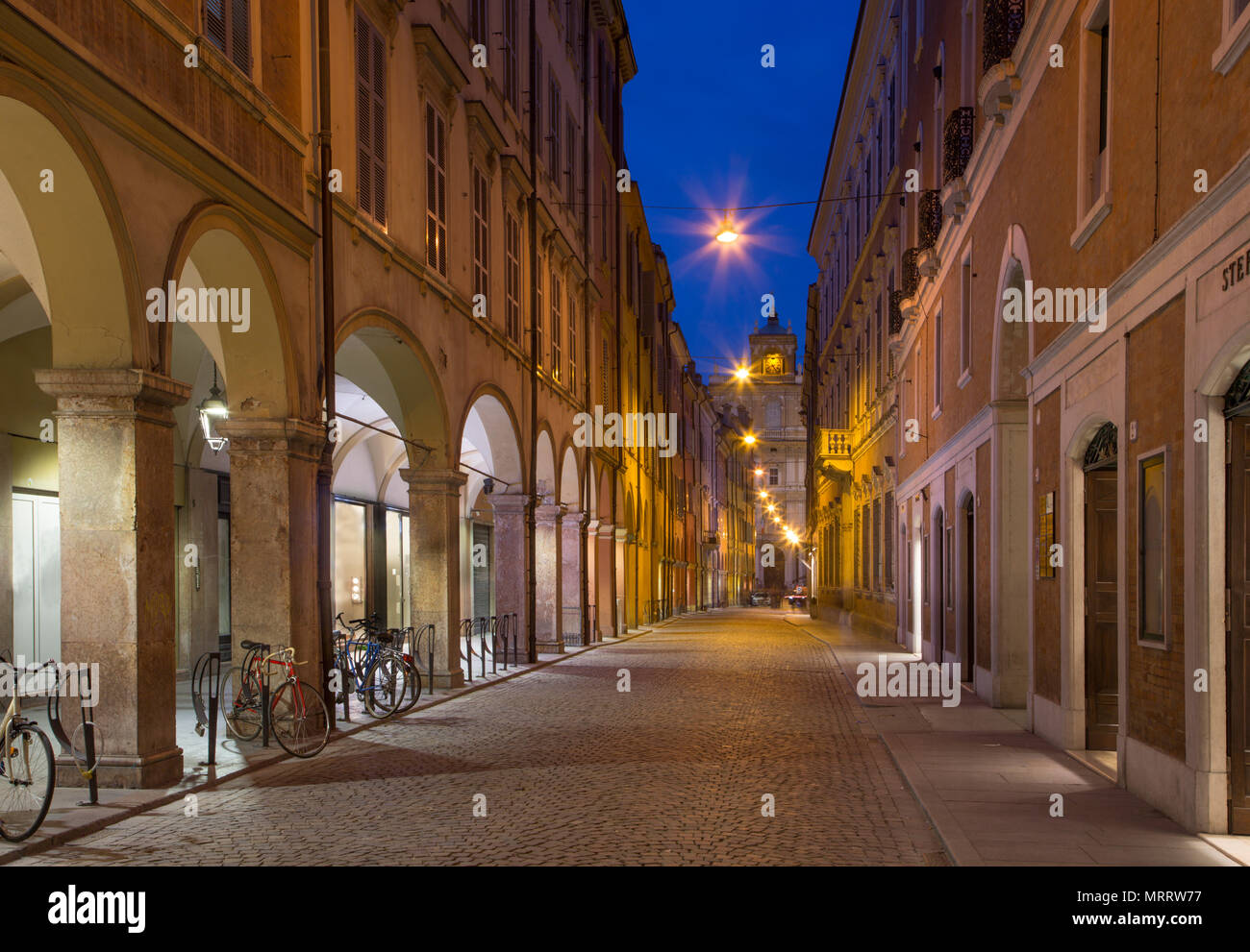 Modena - Via Roma Street und der Militärakademie im Hintergrund in der Abenddämmerung. Stockfoto