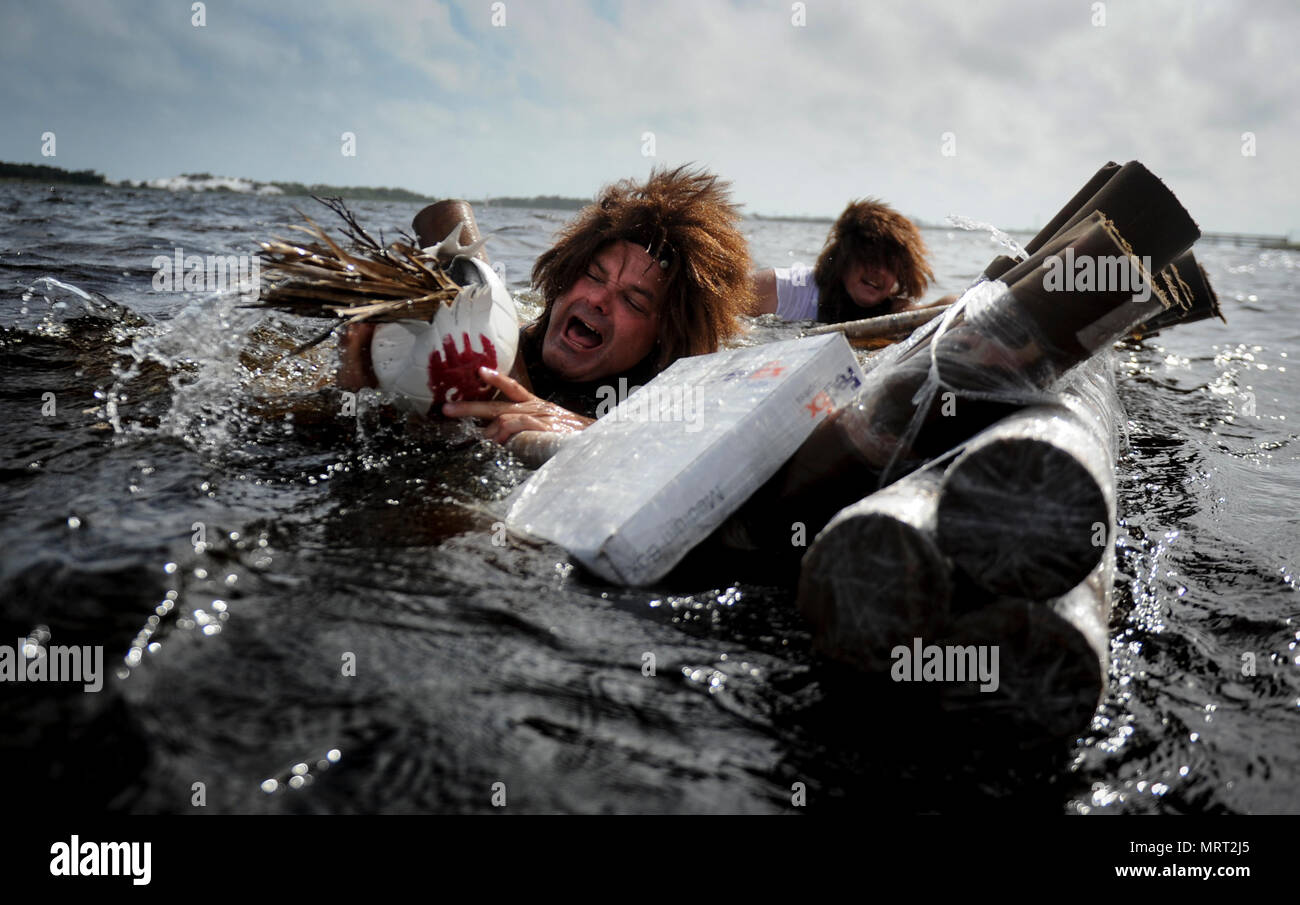 Mike Raynor, Links, und Stuart Camp, Public Affairs Spezialisten mit Air Force Special Operations Command Public Affairs, Waschbecken im Karton Yacht Regatta an hurlburt Field, Fla., 24. Juni 2017. Raynor und Camp verkleidet als Schauspieler Tom Hanks' Zeichen aus dem berühmten Film "Cast Away." (U.S. Air Force Foto von Flieger 1. Klasse Dennis Spanien) Stockfoto