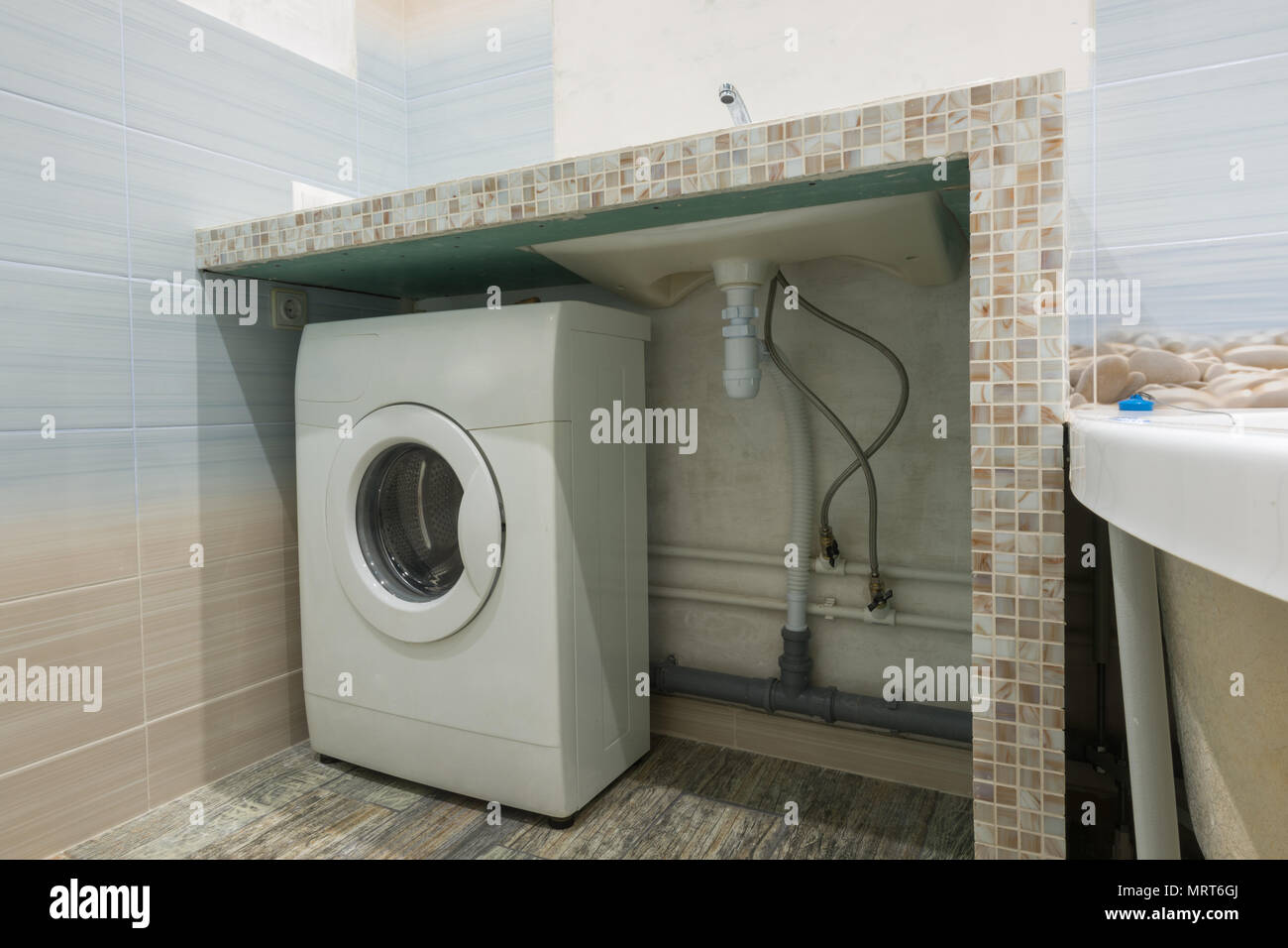 Hausgemachte Sockel im Waschbecken im Bad, Platz für eine Waschmaschine  Stockfotografie - Alamy