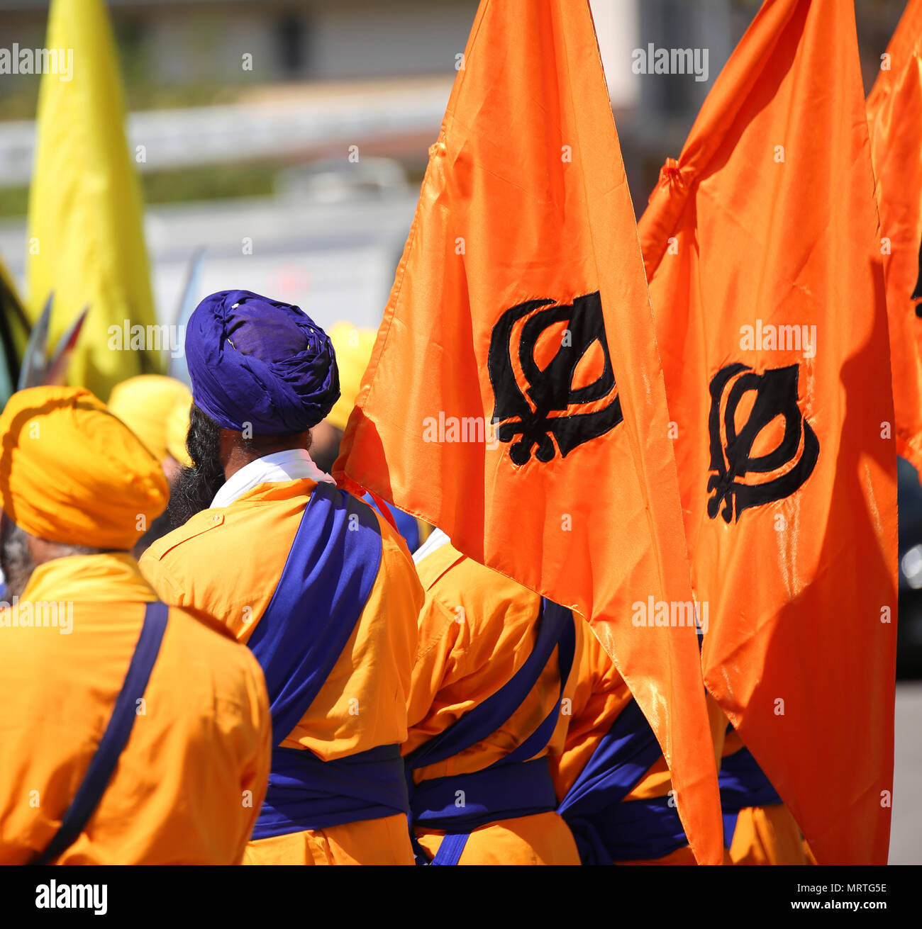 Männer mit orange Flaggen und Sikh symboll KHANDA genannt bei religiösen Ritus Stockfoto