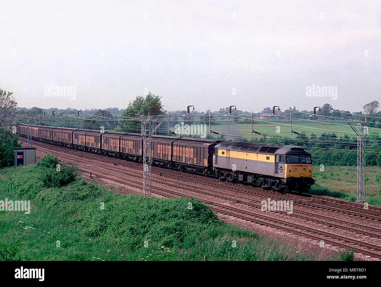 Eine Klasse 47 Diesellok Nummer 47329 mit einem langen Zug Transporter bei Soulbury am 6. Juni 1994. Stockfoto