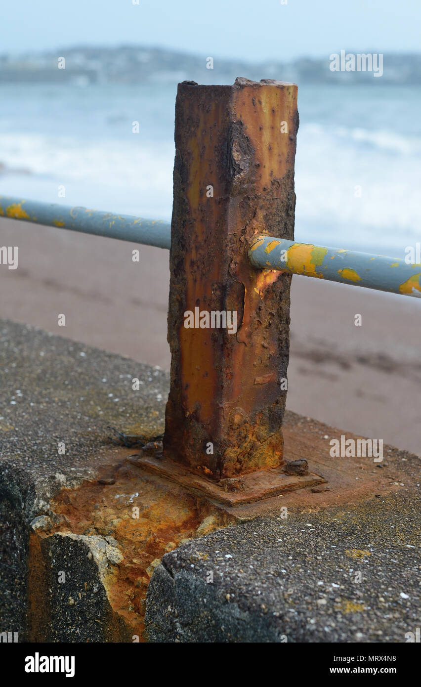 Rusty Beiträge und Geländer entlang dem Meer an der Wand. Stockfoto