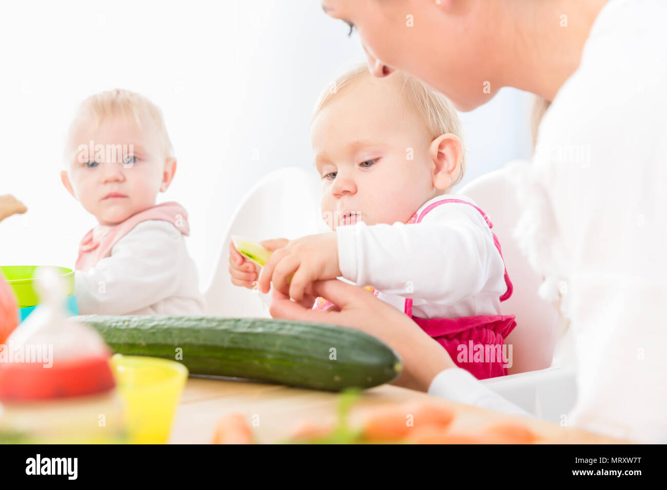 Cute Baby Mädchen gesund essen feste Nahrung in eine moderne Kindertagesstätte Stockfoto