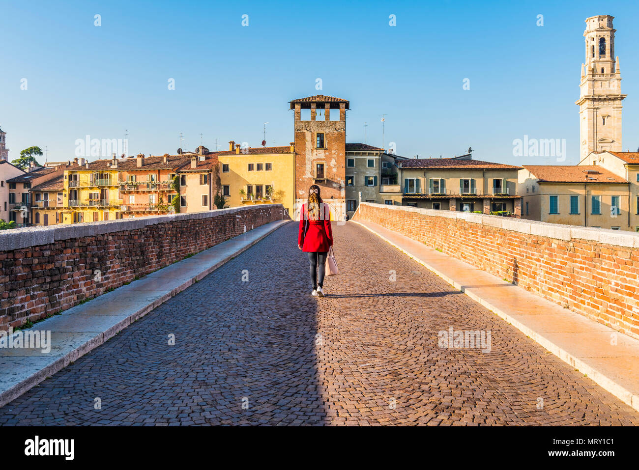 Frau wandern entlang der Ponte Pietra (Steinbrücke). Verona, Venetien, Italien Stockfoto