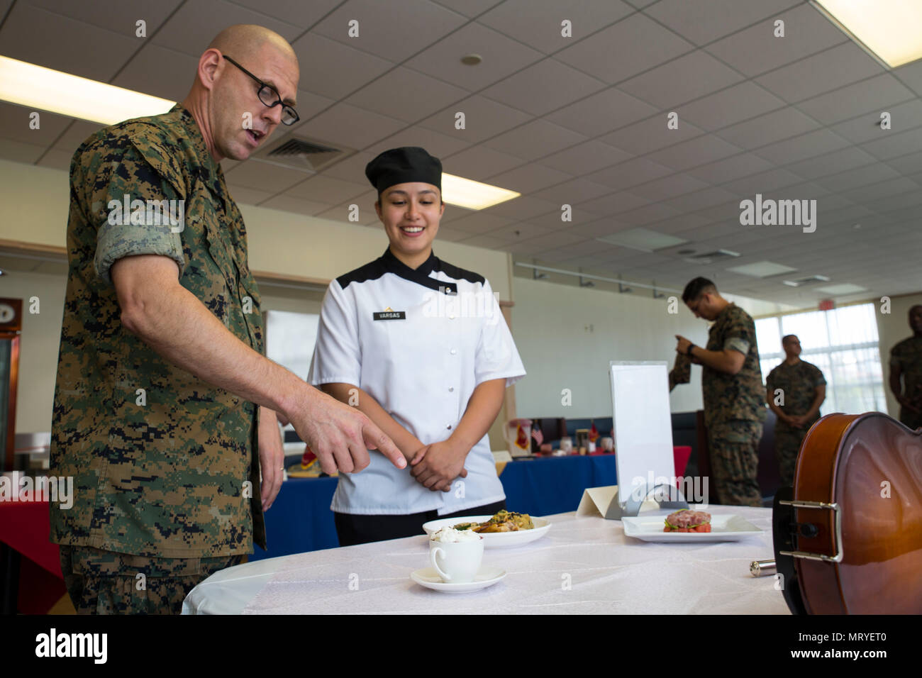 Us Marine Corps Sgt. Maj. Jason R. Kain, Links, Sergeant Major der Sitz und die Hauptverwaltung Squadron (H&HS), spricht mit Lanze Cpl. Erika Vargas, Recht, ein Food Service Spezialist mit, über die Dunkle Schokoladenmousse, die Sie für den Food Service Spezialist für das Quartal Wettbewerb auf der Marine Corps Air Station (WAB) Iwakuni, Japan, 13. Juli 2017 vorbereitet. Die Veranstaltung vorbereitet Marines für einen grösseren Wettbewerb Juli 226-27 in Okinawa. Vargas den ersten Platz, ihre Platzierung im letzten Quartal übertroffen. (U.S. Marine Corps Foto von Lance Cpl. Gabriela Garcia-Herrera) Stockfoto