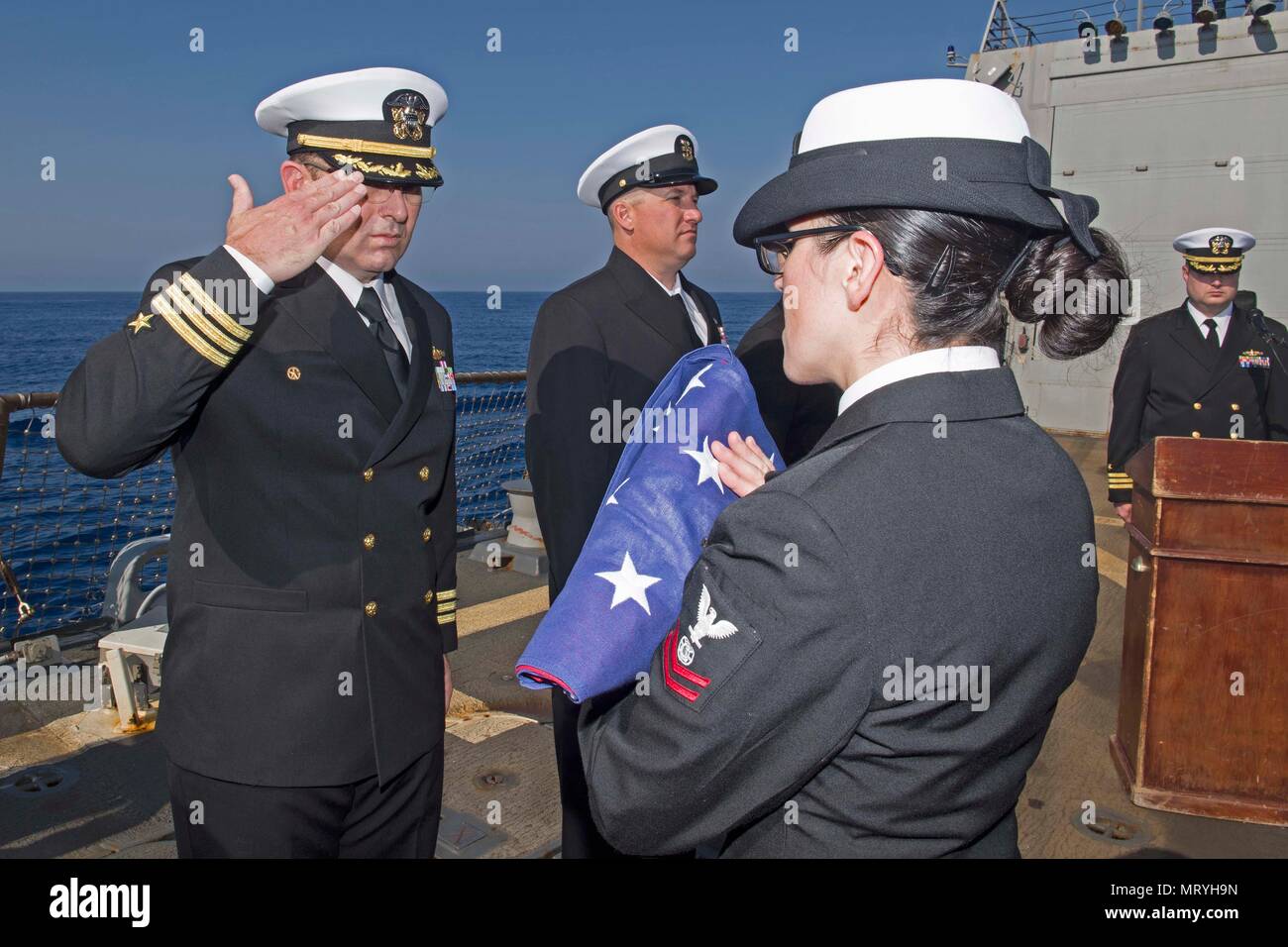 170716-N-NB 178-088 MITTELMEER (16. Juli 2017) Cmdr. Troy Denison, kommandierender Offizier der geführten Anti-raketen-Zerstörer USS Truxtun (DDG103) macht ein Gruß als religiöse Programme Specialist 2. Klasse Maria Perez bereitet den Stern während einer Beerdigung zu Pass-auf-see Zeremonie. Truxtun, Teil der George H.W. Bush Carrier Strike Group (GHWBCSG), ist die Durchführung von naval Operations in den USA 6 Flotte Bereich der Maßnahmen zur Unterstützung der US-amerikanischen nationalen Sicherheitsinteressen in Europa und Afrika. (U.S. Marine Foto von Mass Communication Specialist 1. Klasse Tyrell K. Morris/Freigegeben) Stockfoto