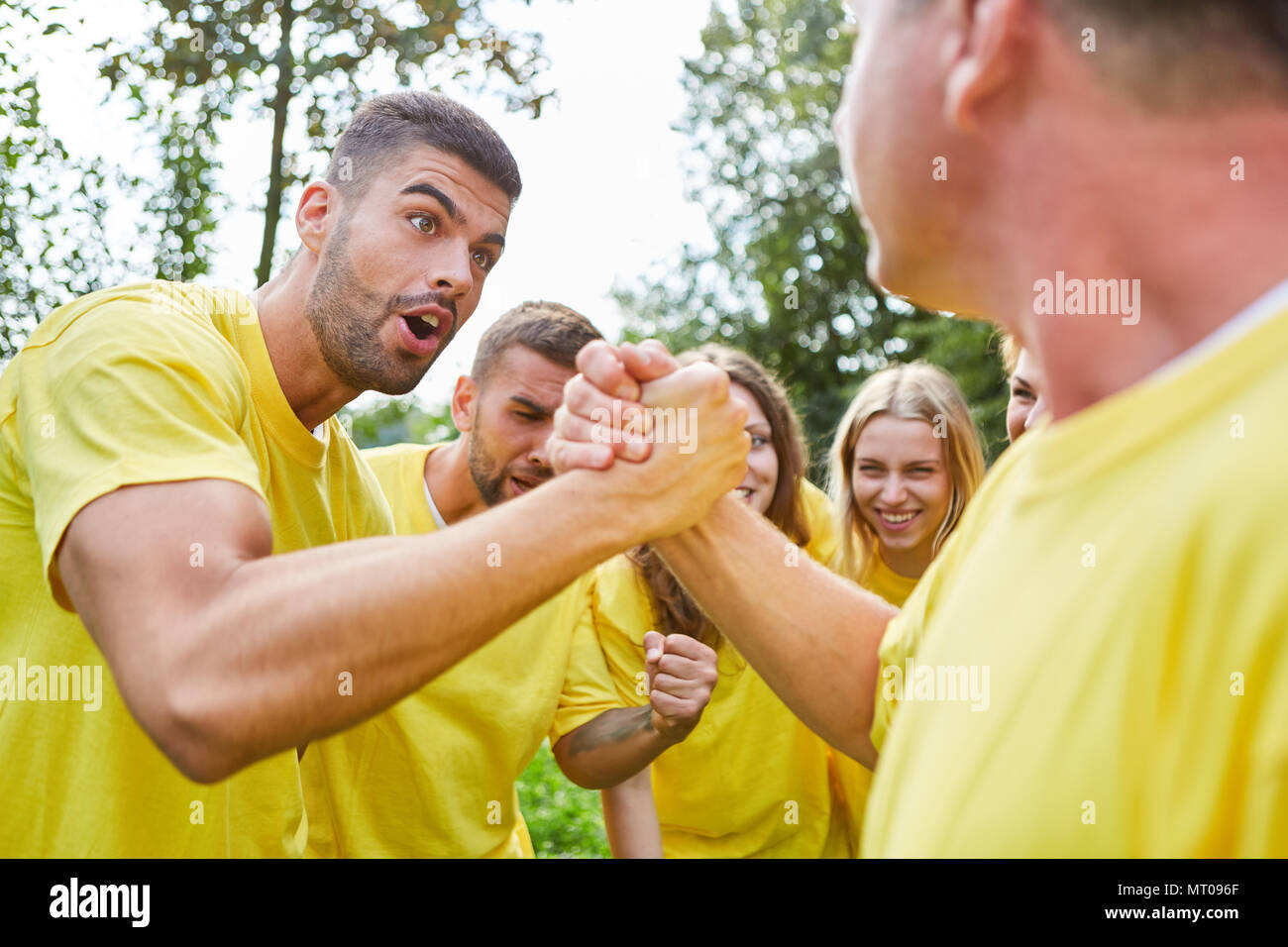 Erstaunt mann Arm Wrestling in einem Wettbewerb an der Teambuilding-event Stockfoto