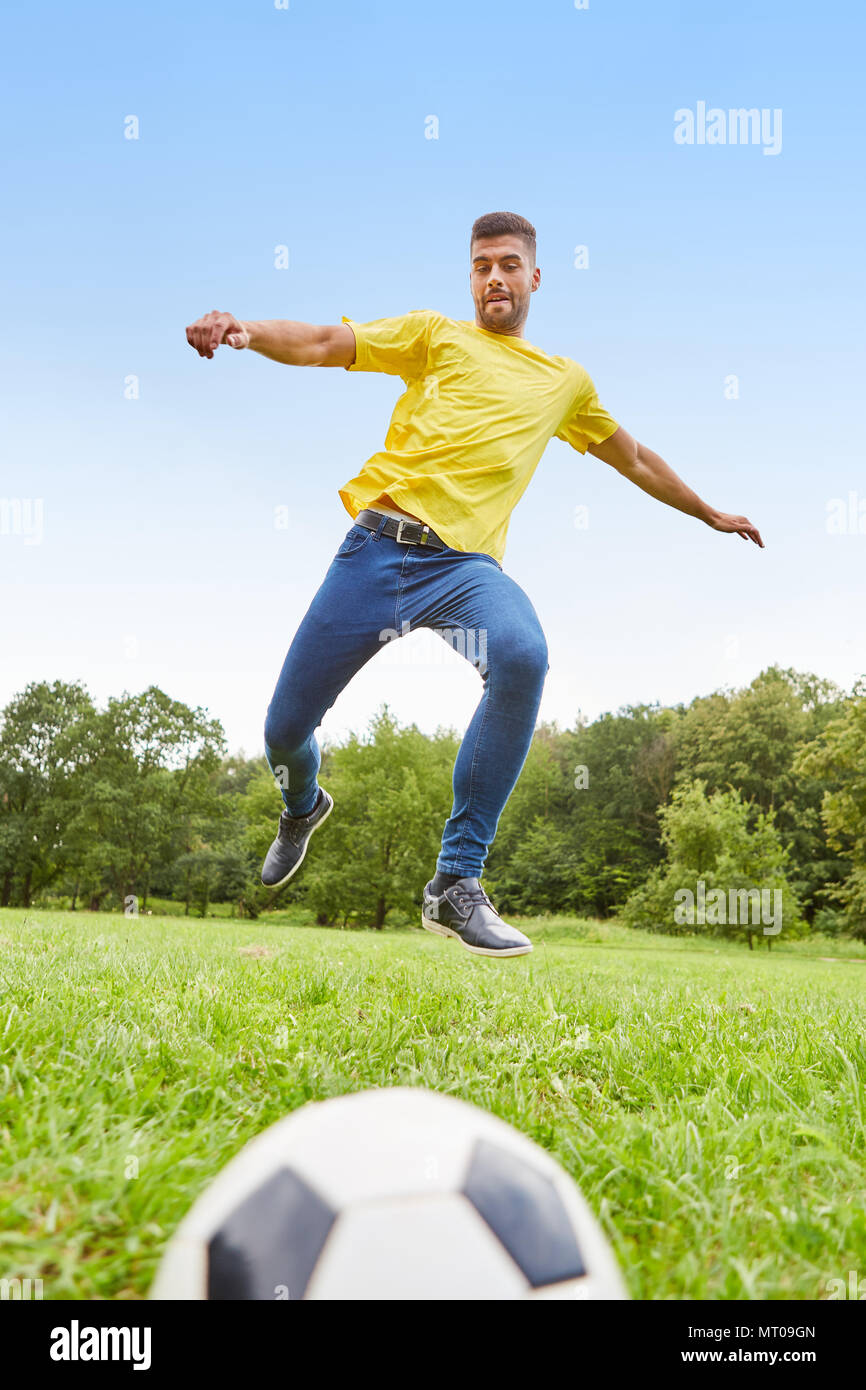 Junge sportliche Menschen als Fußballer zieht für ein Scoring auf der Wiese Stockfoto