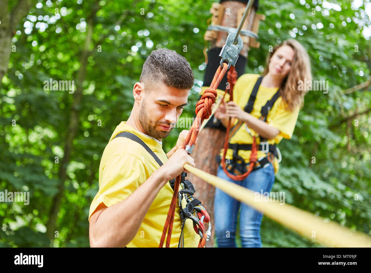 Junge Mann geht über eine Brücke und kämpft gegen die Schwindel roped Stockfoto