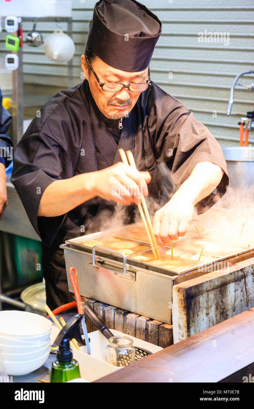 Indoor Omicho Ichiba, Omicho Markt, dem größten Markt mit frischen Lebensmitteln in Kanazawa, Japan. Mann Kochen bei Fisch Essen zum Mitnehmen. Stockfoto