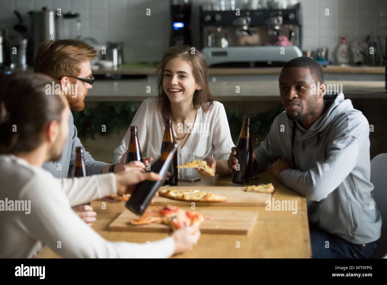 Lächelnd multirassischen junge Freunde sprechen Bier trinken essen p Stockfoto