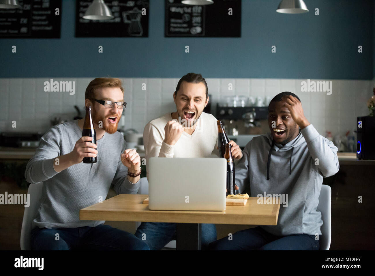 Multirassischen Männer trinken Bier feiern Sieg Wildbeobachtung Stockfoto