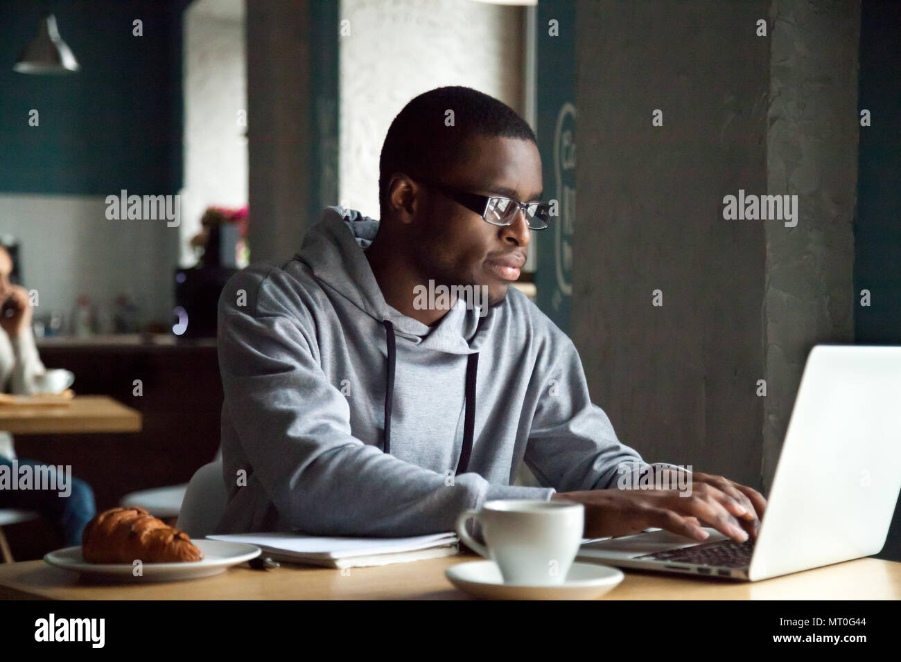 Ernsthaften tausendjährigen afrikanischen amerikanischen Mann mit Laptop sitzen an Stockfoto