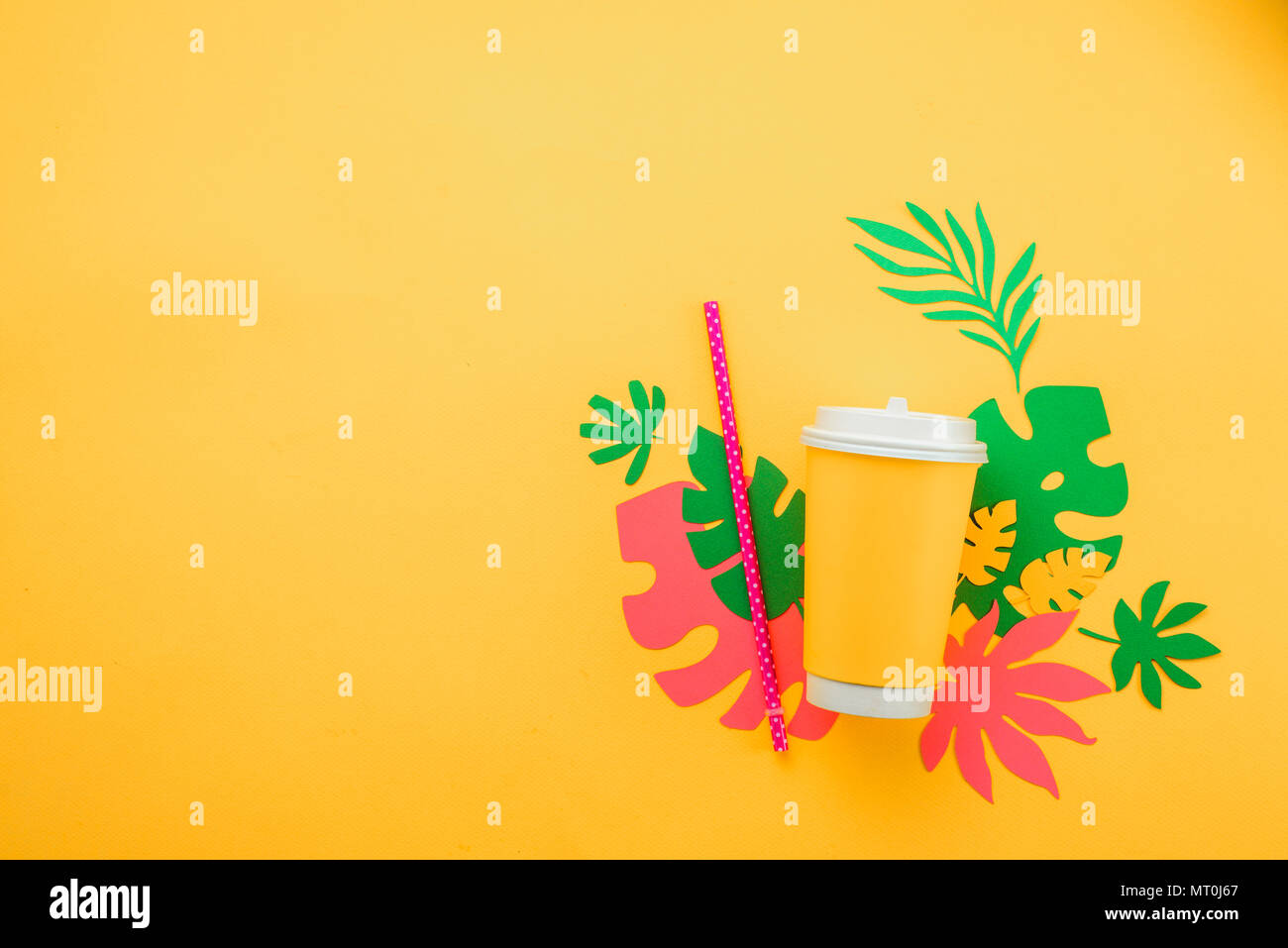Frische Sommer drink-Konzept. Verfügbare Pappbecher mit einem Strohhalm auf gelbem Hintergrund mit tropischen Blättern Stockfoto