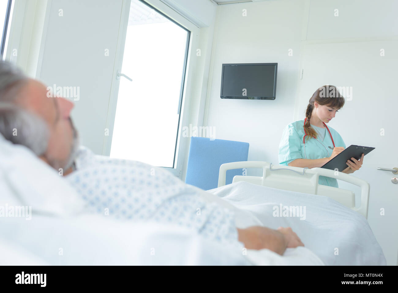 Arzt Notizen Von Man Patient Im Krankenhaus Bett Liegen Stockfotografie Alamy