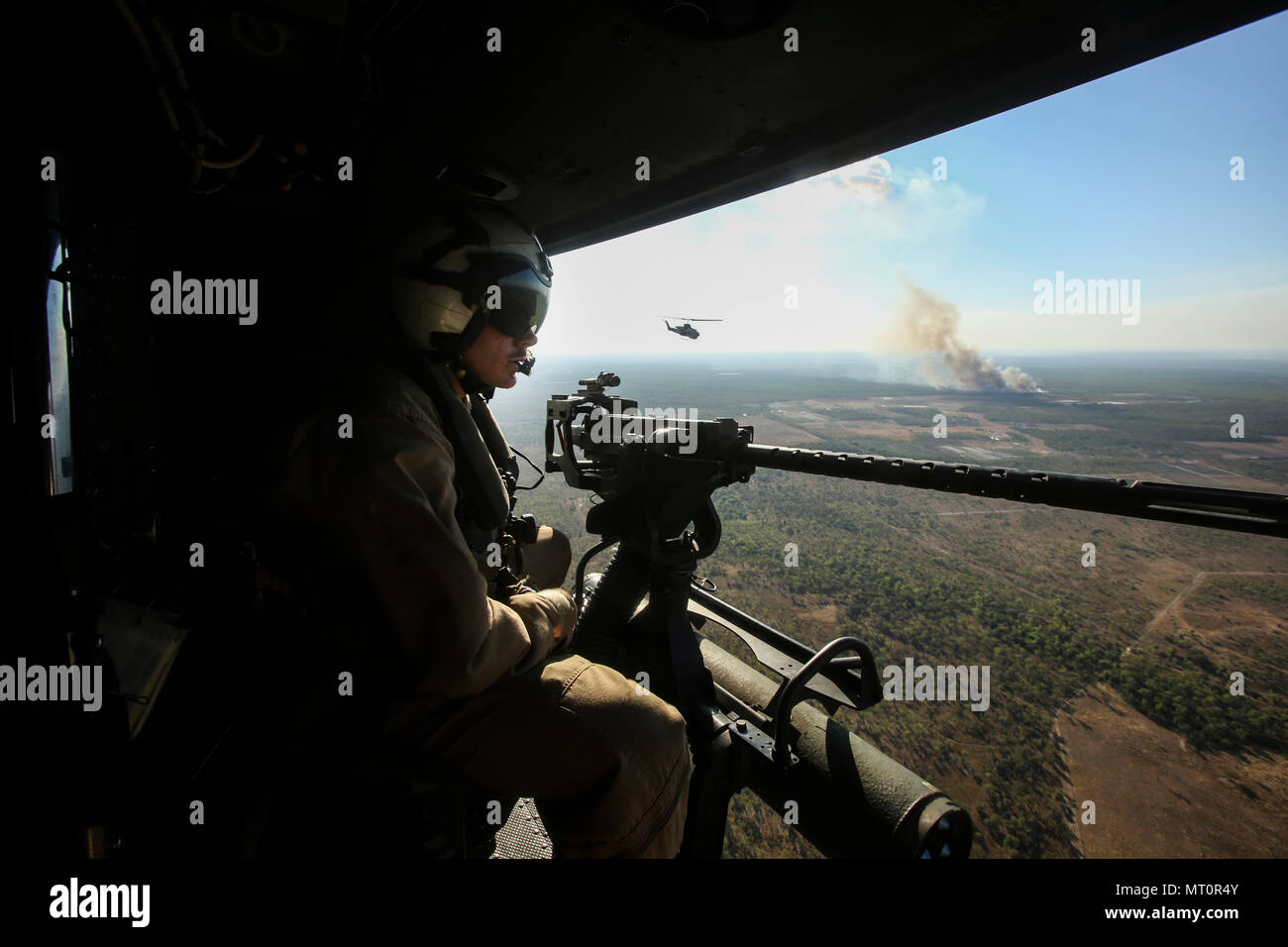 NORTHERN TERRITORY, Australien - US Marine Cpl. Tannyr Novak, Crew Chief, Marine Light Attack Helicopter Squadron 367, Marine Drehkraft Darwin, nimmt in der Ansicht während des Fluges zu einer Antenne gun Angebot am Berg Bundey Training Area, 21. Juni 2017. Während der Ausbildung, Piloten und Besatzungsmitglieder genau engagierte Ziele mit geführten Raketen, M2 .50 Kaliber Maschinenpistole und M240B Medium Maschinengewehr aus einer UH-1Venom. Novak ist aus Nashville, Illinois (USA Marine Corps Foto von Sgt. Emmanuel Ramos) Stockfoto