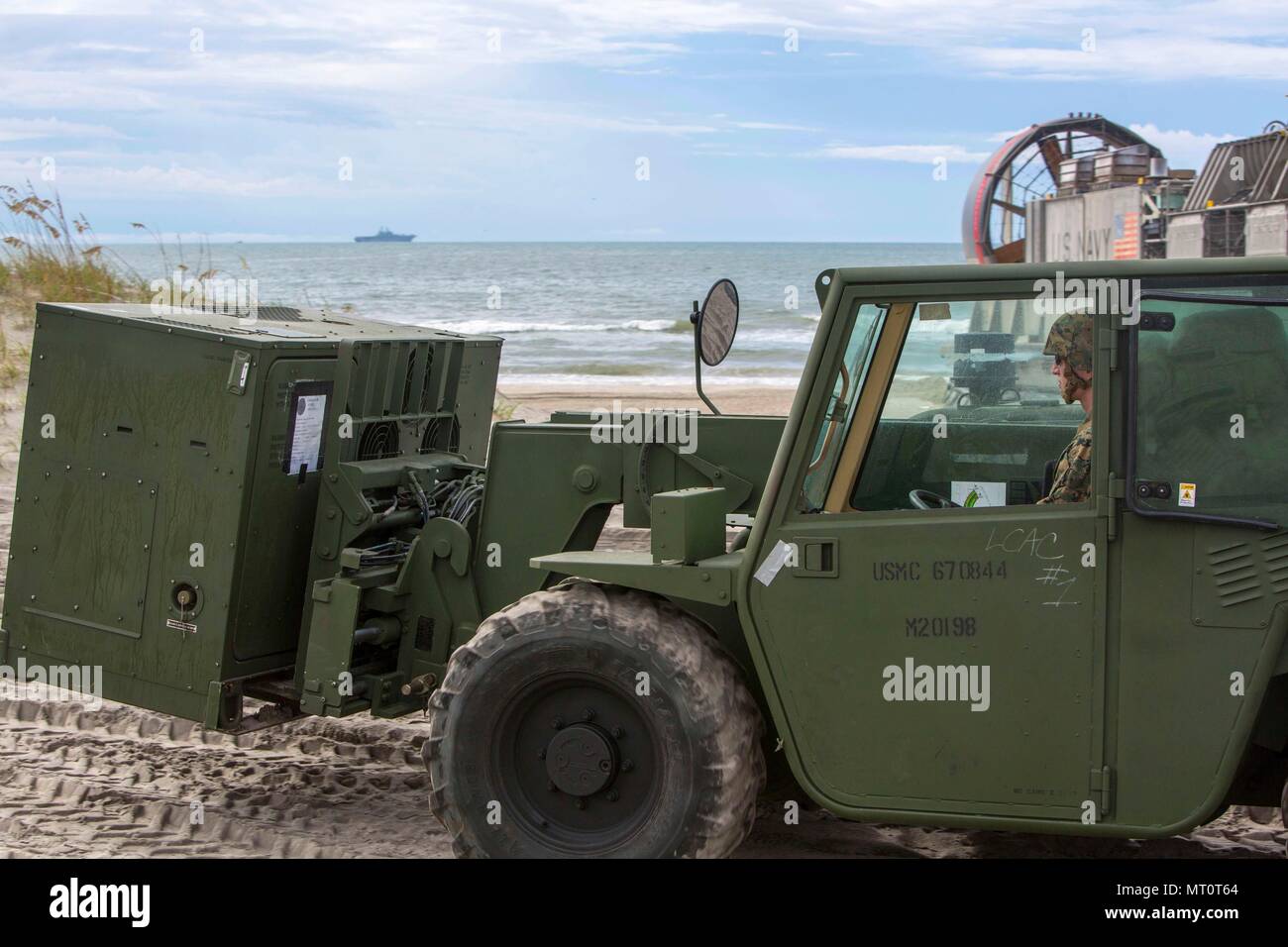 Lance Cpl. Nicholas L. Allen, ein Ingenieur Ausrüstung Fahrer bekämpfen Logistik Bataillon 26, 26 Marine Expeditionary Unit (MEU), transportiert einen Generator mit einem Gabelstapler während der Amphibischen Squadron - MEU Integration Training (PMINT) in Onslow Strand, N.C., 17. Juli 2017. PMINT erlaubt die Navy-Marine Corps Team zur Verbesserung der Interoperabilität und die einzigartigen Funktionen des Amphibious Task Force Übung. (U.S. Marine Corps Foto von Sgt. Clemente C. Garcia/Freigegeben) Stockfoto