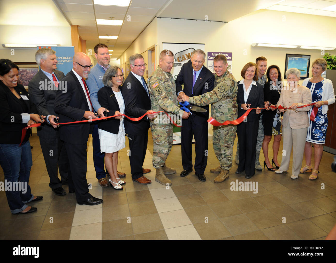 Generalmajor Mark Stammer, ich Corps Stellvertretenden Kommandierenden General (Mitte links) mit Washington Gouverneur Jay Inslee (Mitte) und Oberst Dan Morgan, Joint Base Garrison Commander (mitte-rechts), auf dem großen Schere Team und anderen örtlichen, regionalen und nationalen Führer für die Multifunktionsleiste Schneiden der WorkSource/American Job Center an der Joint Base Lewis-McChord Hawk Transition Zentrum, 7. Juli 2017 beitreten. Stockfoto