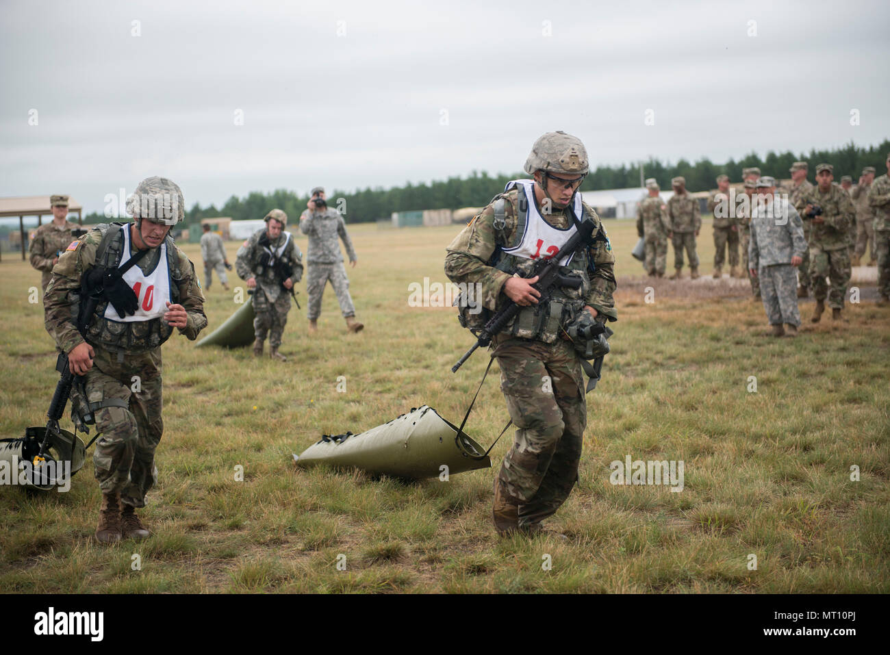 Spc. Wacey Connor (links), ein Healthcare Spezialist mit HHB, 2-142 nd Brände Brigade, Arkansas National Guard, und Cpl. Joseph Garback (rechts), eine Kanone crewmember mit B Co., 1st Bataillon, 114 Infanterie, 50th Infantry Brigade Combat Team, New Jersey der National Guard, der schleppt ein 100-Pfund, um die Ziellinie des unbekannten Abstand zum automatischen Scharfschalten Veranstaltung am 18. Juli 2017, am Lager Ripley, Minn., während der 2017 Army National Guard besten Krieger Wettbewerb. Dieses Ereignis fand direkt nach der Armee körperliche Fitness zu prüfen, und bestand aus einem 2-Meile laufen mit verschiedenen Aufgaben, einschließlich der Durchführung von Crawling unter Barb Stockfoto