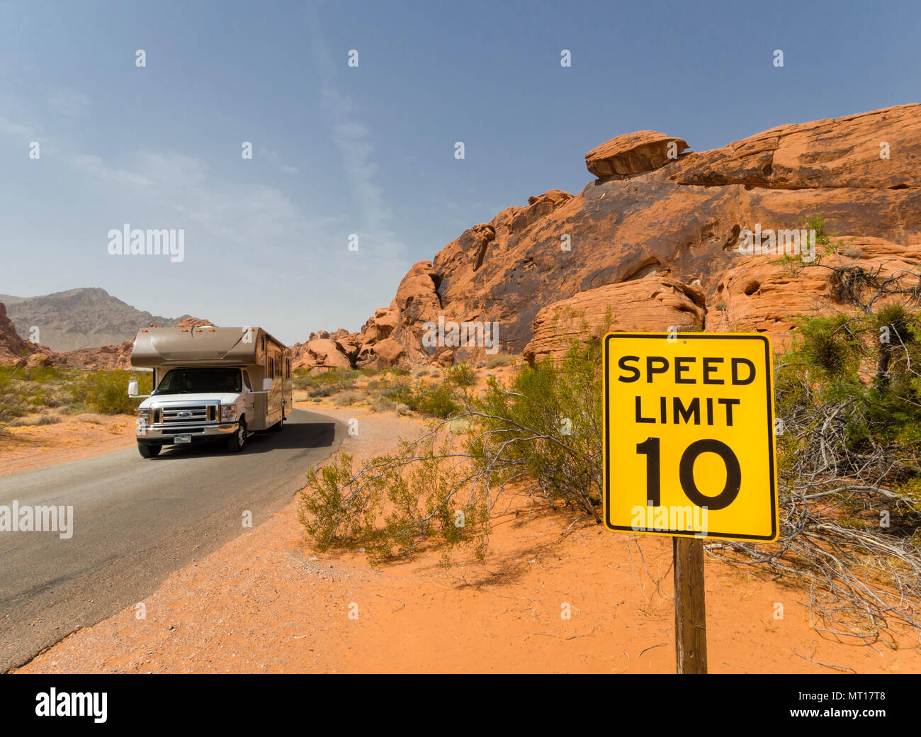 Ein RV Motor home ist vorbei, eine Höchstgeschwindigkeit Zeichen in der Wüste von der Gasse von Fire State Park (Nevada, USA) Stockfoto