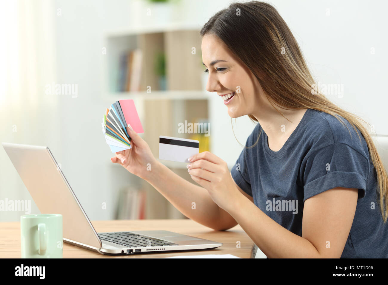 Happy shopper online kaufen mit mehreren Kreditkarten und ein Laptop zu Hause Stockfoto