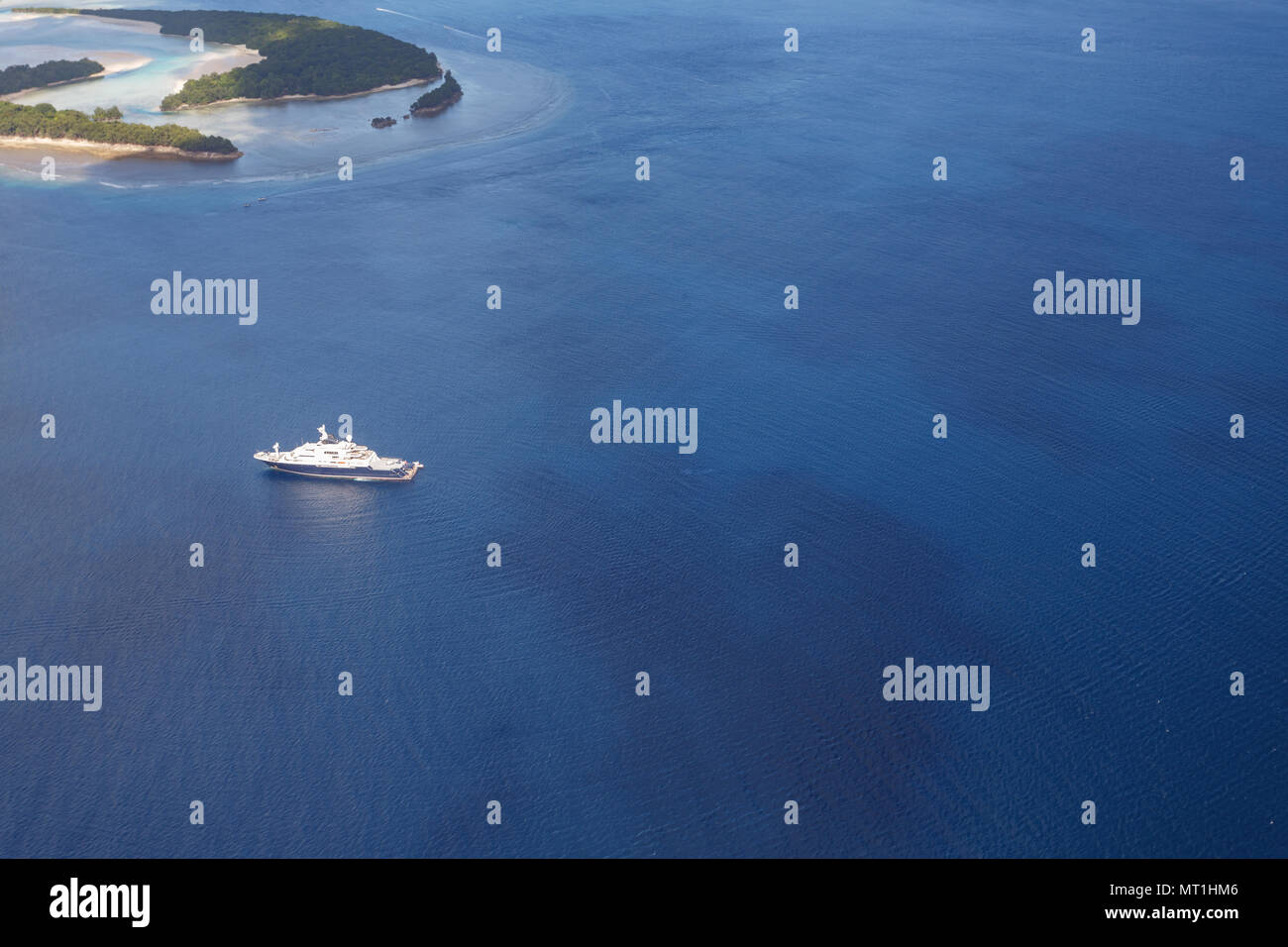 Blau und Weiß Mega Yacht gleitet inmitten von tropischen Inseln in pazifischen Gewässern Stockfoto