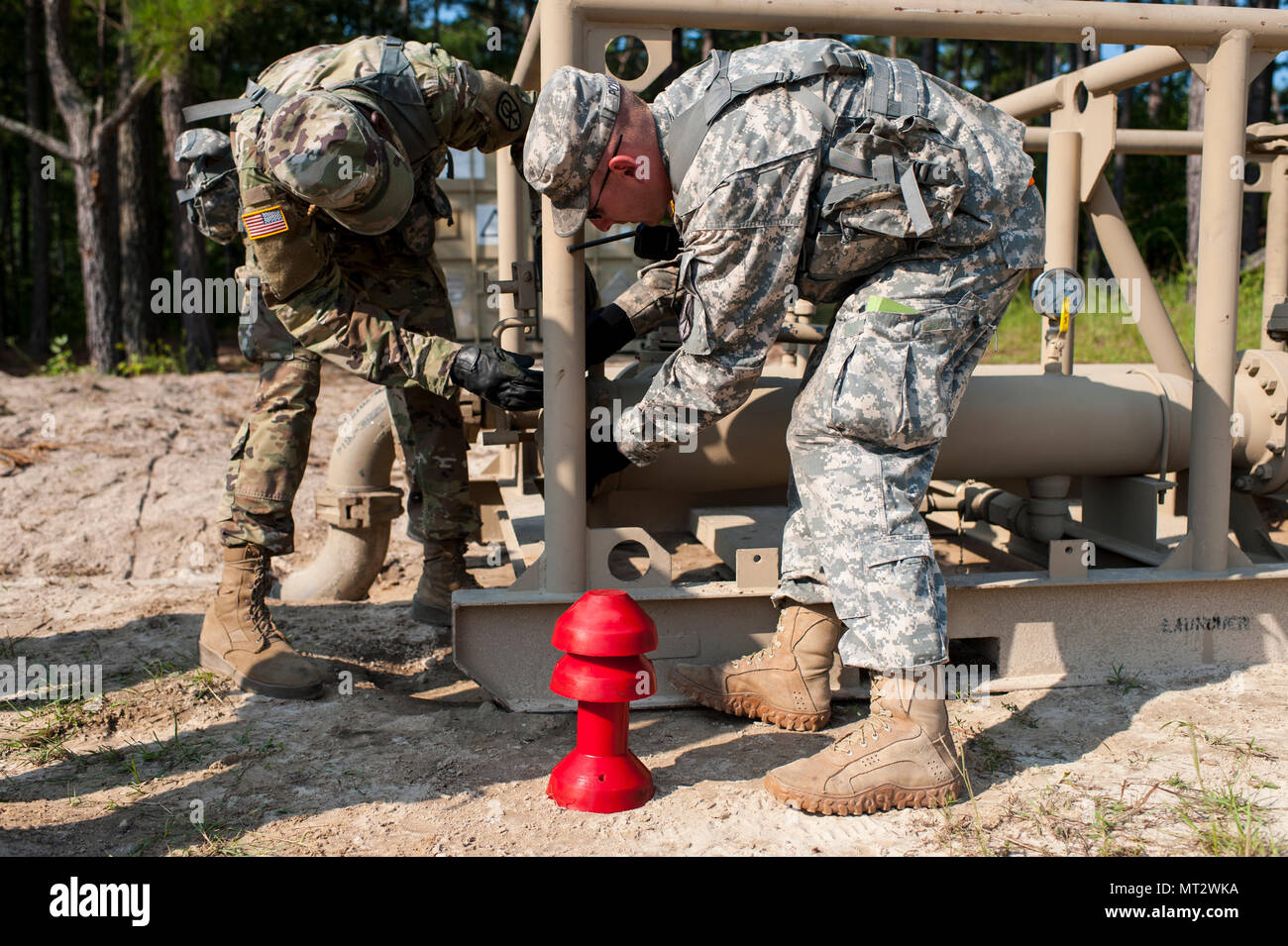 U.S. Army Reserve Soldaten mit der 728Th Quartermaster Unternehmen, Fremont, Neb., bereiten Sie ein 'pig zu rücken", durch die Leitungen während QLLEX 2017, 21. Juli in Fort Bragg, NC. Es ist ein 'Pig' genannt, weil, wie es durch die Leitung unter Druck bewegt, macht es oft ein hohes Pfeifen. QLLEX, kurz für Quartermaster Flüssiglogistik ausüben, ist Premier der US-Armee finden Bereitschaft Übung für Kraftstoff und Wasser Verteilung. Die diesjährigen QLLEX ist nicht nur eine Demonstration der Leistungsfähigkeit, Einsatzbereitschaft und Letalität von America's Army Reserve Kraftstoff und Wasser zu setzen, wo sie am meisten gebraucht wird - Stockfoto