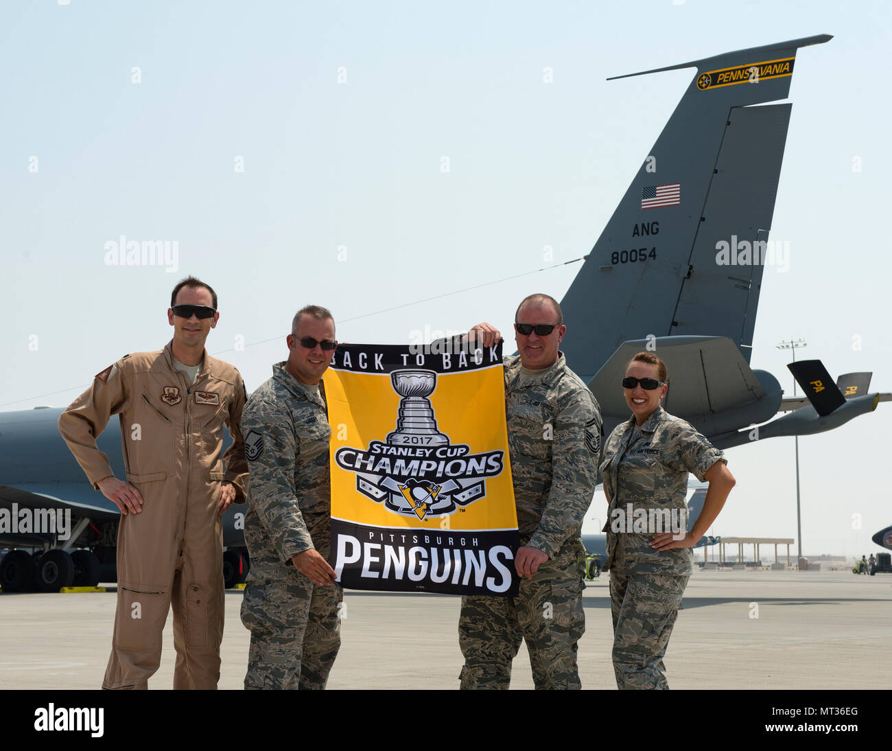 Us Air Force Oberstleutnant Matthew Meshanko, Leiter Sicherheit, Links, Master Sgt. Christopher Lindsey, Sicherheit, Senior Master Sgt. Richard Oram, Sicherheit und Tech. Sgt. Angela Posadas, Boden Sicherheit mit dem 379 Air Expeditionary Wing Safety Office, posieren für ein Foto mit einer Pittsburgh Penguins Stanley Cup Champion Banner vor einem KC-135 Stratotanker von der 171St Air Refuelling Flügel, Pennsylvania Air National Guard bei Al Udeid Air Base, Katar, 25. Juli 2017. Lindsey und Oram, reservisten mit der 911Th Airlift Wing, Pittsburgh Luft finden, sind verantwortlich für die Prüfung Stockfoto