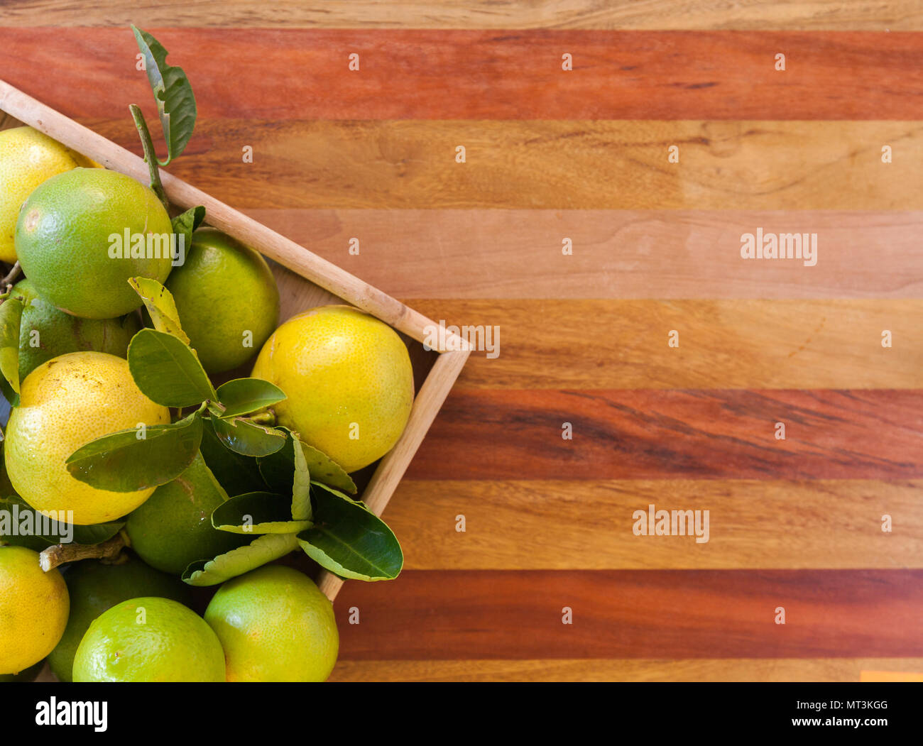 Key Lime oder mexikanischen Kalk in einer Holzkiste auf dem Boden, ein Hauptbestandteil der thailändischen Küche und traditionelle Torte. freier Platz für Text Stockfoto