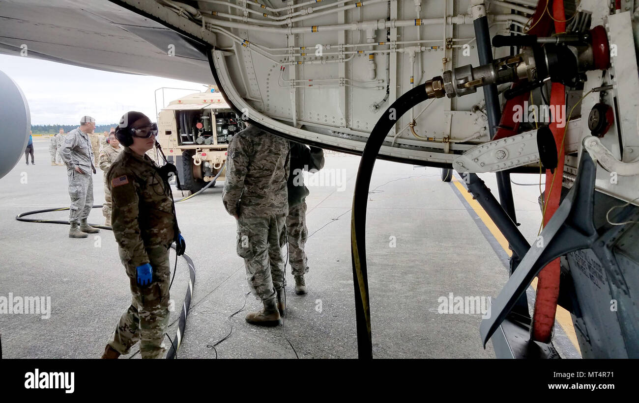 Spezialist Tiffany Boggs, E Co., 1st Bataillon (allgemeine Unterstützung), 168 Aviation Regiment, Kontrollen auf die Verbindung von einem Tanker Variante des Heavy Expanded Mobility Tactical Truck (HEMTT), wie Es siphons Kraftstoff aus einer KC-135 Stratotanker auf Joint Base Lewis-McChord, 14. Juni 2017. (U.S. Army National Guard Foto von Sgt. 1. Klasse Jason Kriess) Stockfoto