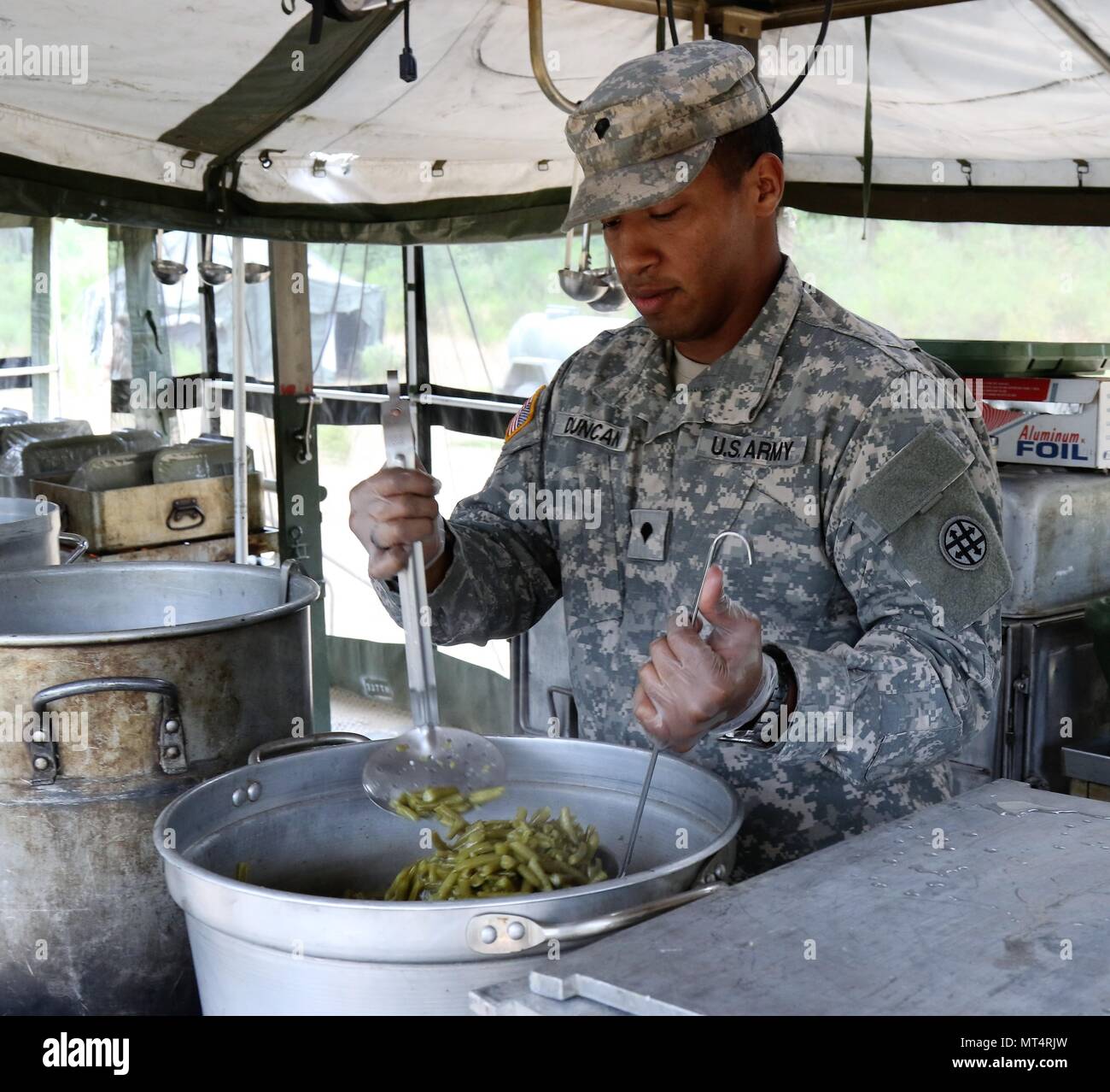 U.S. Army Reserve SPC. Kieth Duncan, einem kulinarischen Fachmann mit der 288Th Quartermaster Gesellschaft, stellt die grüne Bohnen während der zwei Wochen 2017 Quartermaster Flüssiglogistik Übung in Joint Base Lewis McChord, Jan. 14 bis 27, 2017. QLLEX ermöglicht die US Army Reserve Einheiten, um ihr Können unter Beweis zu stellen und der realen Welt Kraftstoff und Wasser unterstützt, während der Ausbildung an der taktischen, operativen und strategischen Ebene. (U.S. Armee finden Foto von Maj. Brandon R. Mace) Stockfoto