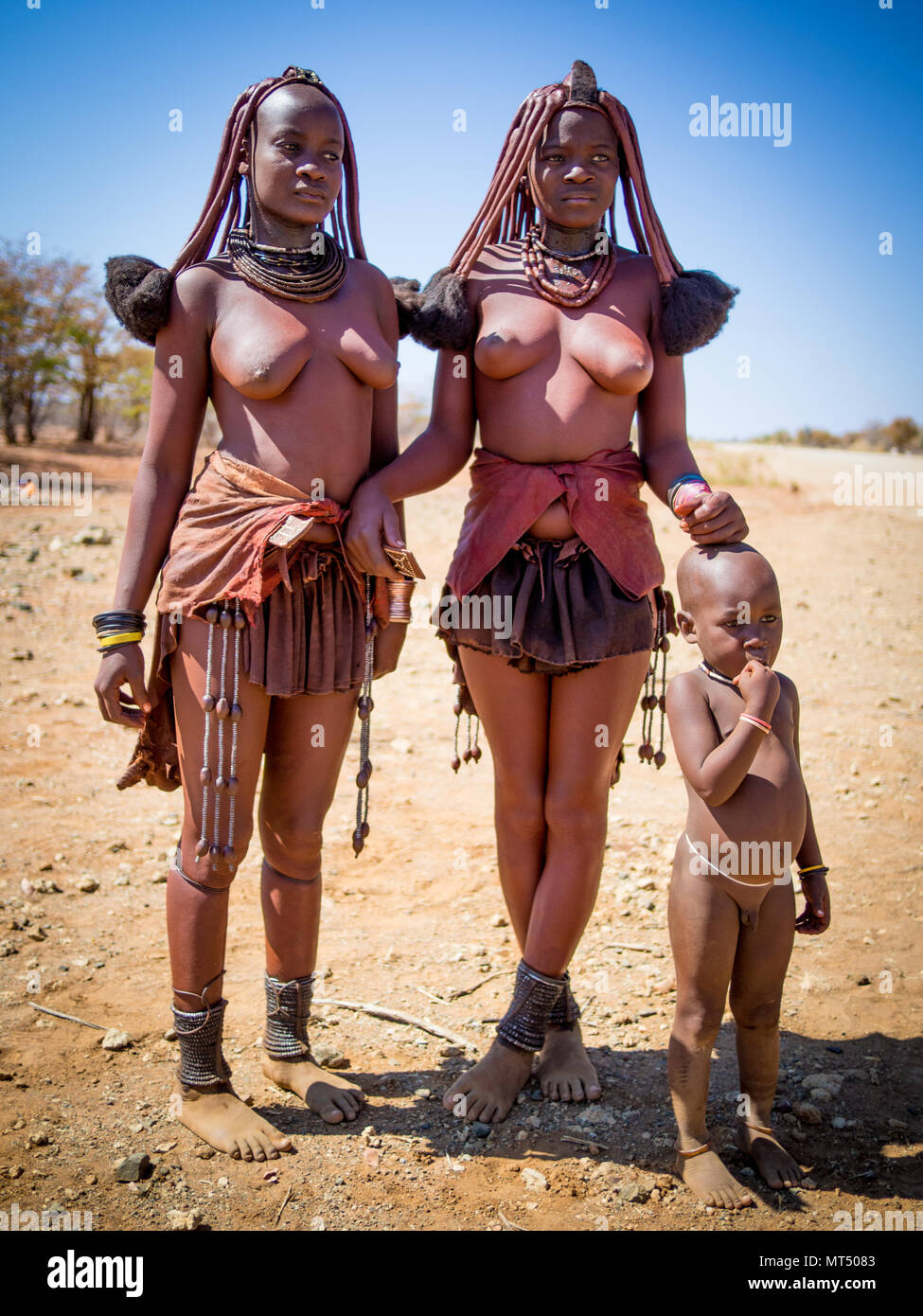 Opuwo, Namibia - 25. Juli 2015: Portrait von nicht identifizierten Himba Frauen, die mit Jungen in der Wüste Stockfoto