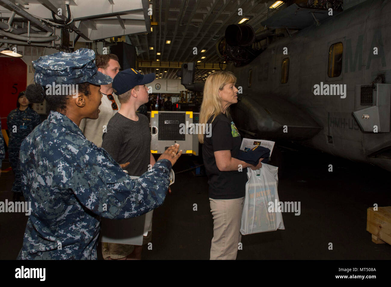 170731-N-NB 544-127 BRISBANE, Australien (31. Juli 2017) der Luftfahrt Bootsmann Mate (Handling) 1. Klasse Marie Bryant (links), erklärt die Funktionen der CH-53E Super Stallion, zugeordnet zu den 'Dragons" der Marine Medium Tiltrotor Squadron (VMM) 265 (Verstärkt) im Hangar Bay an Robert und Terri Irwin bei einer Tour durch das Amphibisches USS BONHOMME RICHARD (LHD6). Bonhomme Richard, dem Flaggschiff der Bonhomme Richard Expeditionary Strike Group (ESG), ist in Brisbane für eine geplante Hafen besuchen. Während der Begehung, Bonhomme Richard Wirt Schiff Touren und die Kultur der Stadt erleben Stockfoto